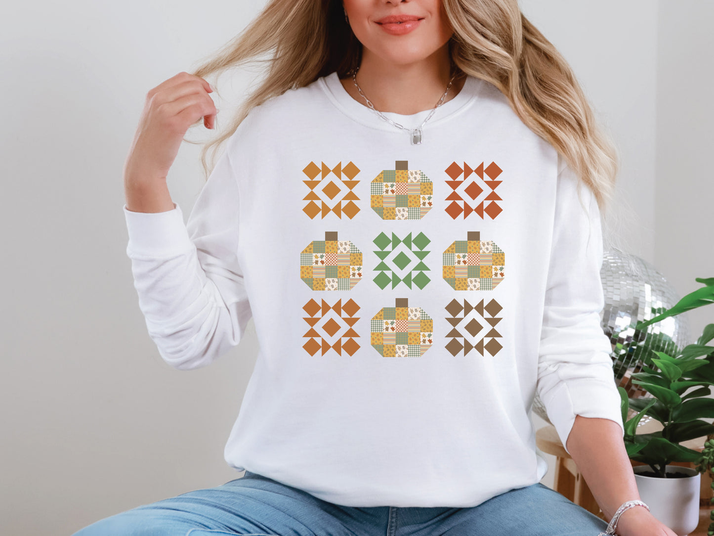 Patchwork pumpkin quilt block long sleeve t-shirt in White with autumn colors by Bee Inspired Tees. Gifts for Quilters, perfect for fall sewing, quilt retreats, and everyday wear.