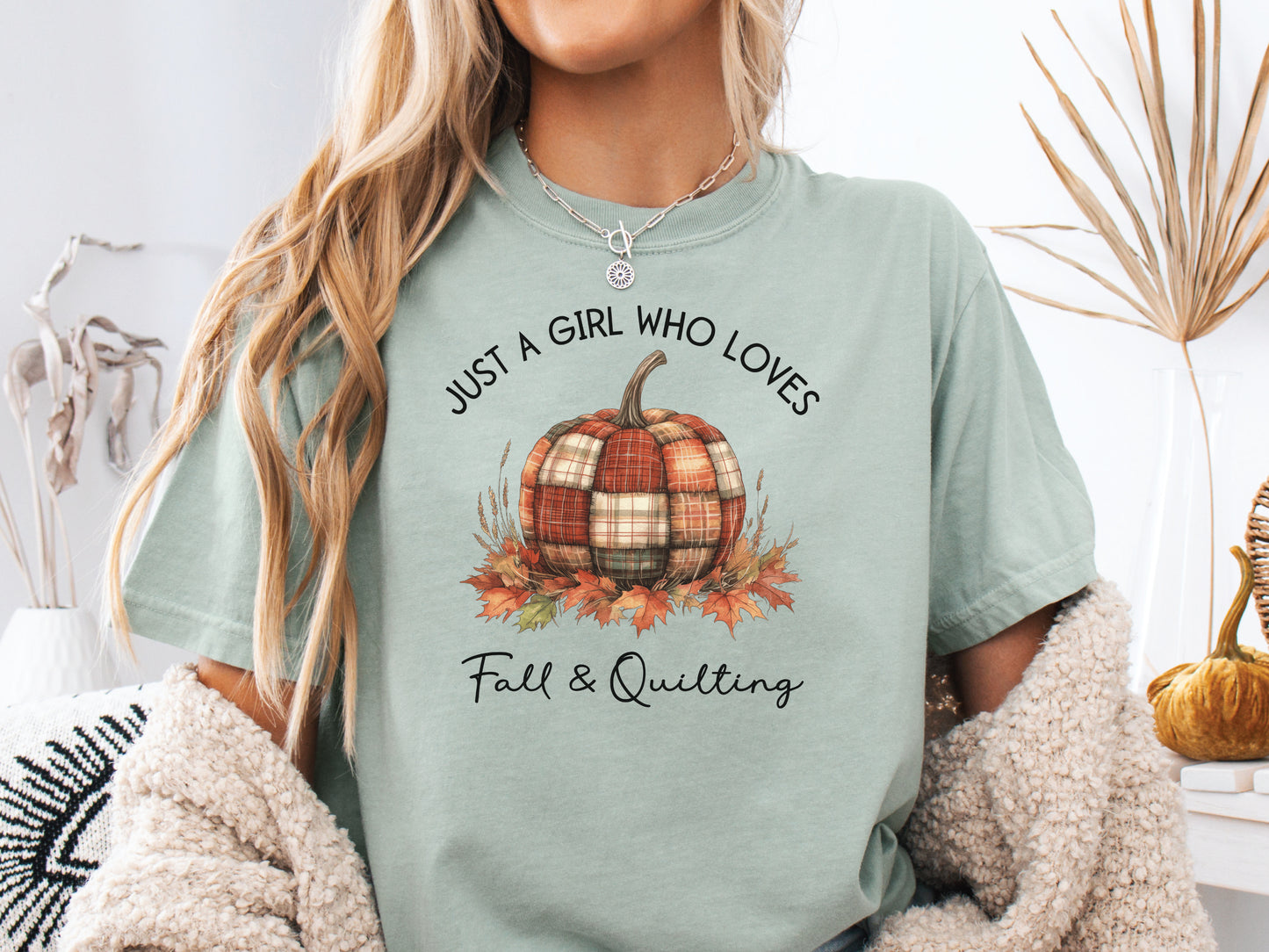 Light Green (Bay) colored t-shirt from Bee Inspired Tees with the phrase “Just a Girl Who Loves Fall & Quilting,” featuring a plaid pumpkin surrounded by autumn leaves. Perfect fall gift for quilters and ideal for quilt retreats or sewing days.