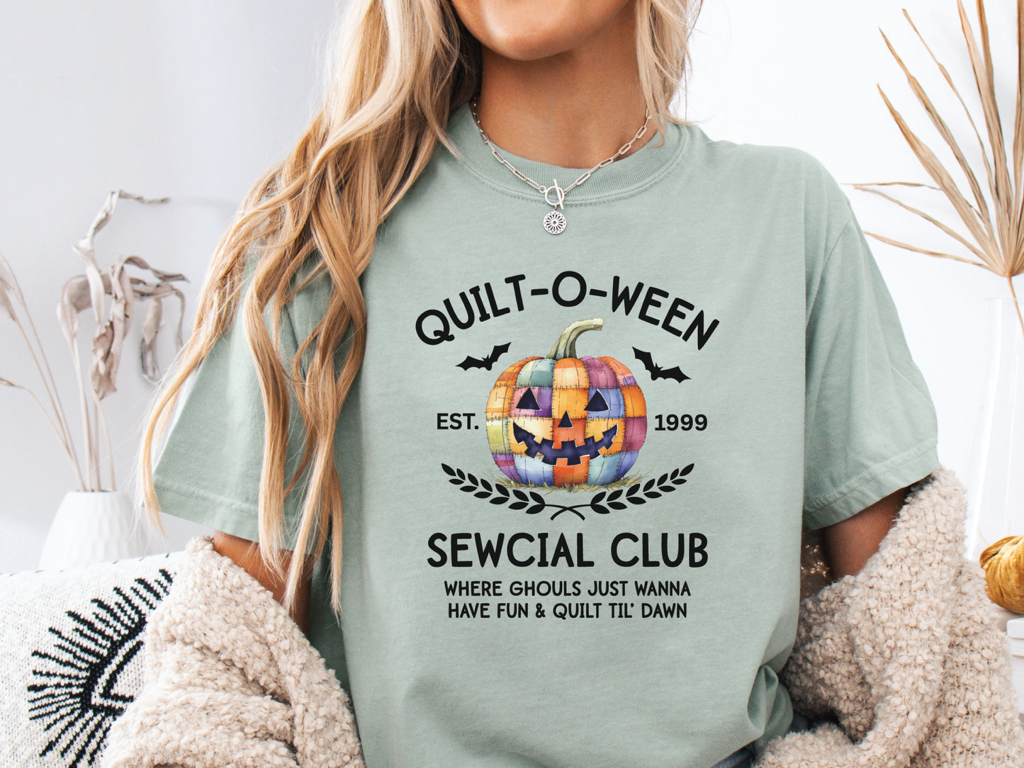 Quilt-O-Ween Sewcial Club shirt from Bee Inspired Tees, designed in Lt.Green (Bay) with a colorful patchwork jack-o’-lantern, bats, and playful Halloween typography—perfect gift for quilters.