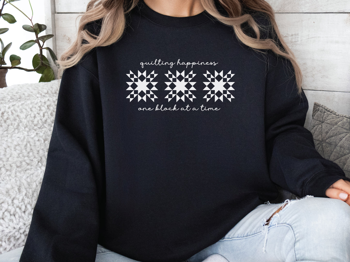Black unisex sweatshirt with the phrase “Quilting Happiness, One Block at a Time,” designed by Bee Inspired Tees. Cozy fall sweatshirt for quilters, ideal for retreats and gifts for quilting lovers.