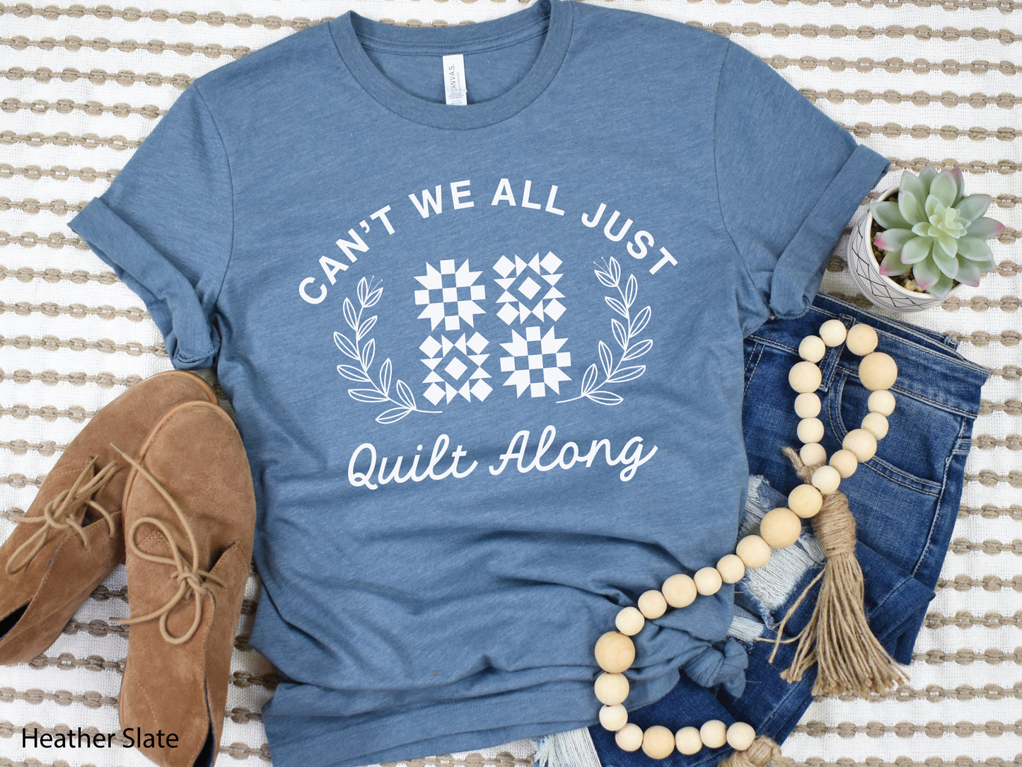 Cozy quilt-themed long sleeve t-shirt with the phrase “Can’t We Just All Quilt Along,” perfect gift for a quilter, ideal for sewing days, quilt retreats, and craft fairs