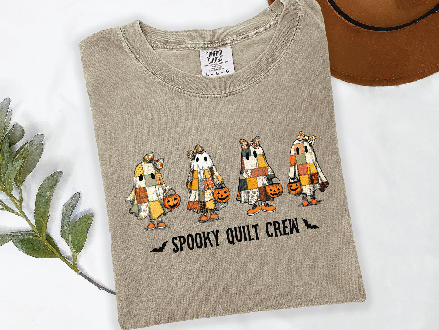 Spooky Quilt Crew Comfort Colors t-shirt from Bee Inspired Tees in Khaki, featuring four patchwork ghosts with jack-o’-lanterns and bold text—fun Halloween gift for quilters.