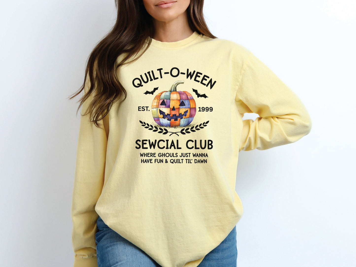 Quilt-O-Ween Sewcial Club long sleeve Yellow (Butter) colored t-shirt from Bee Inspired Tees, featuring a colorful patchwork jack-o’-lantern, bats, and playful Halloween typography—fun gift for quilters.