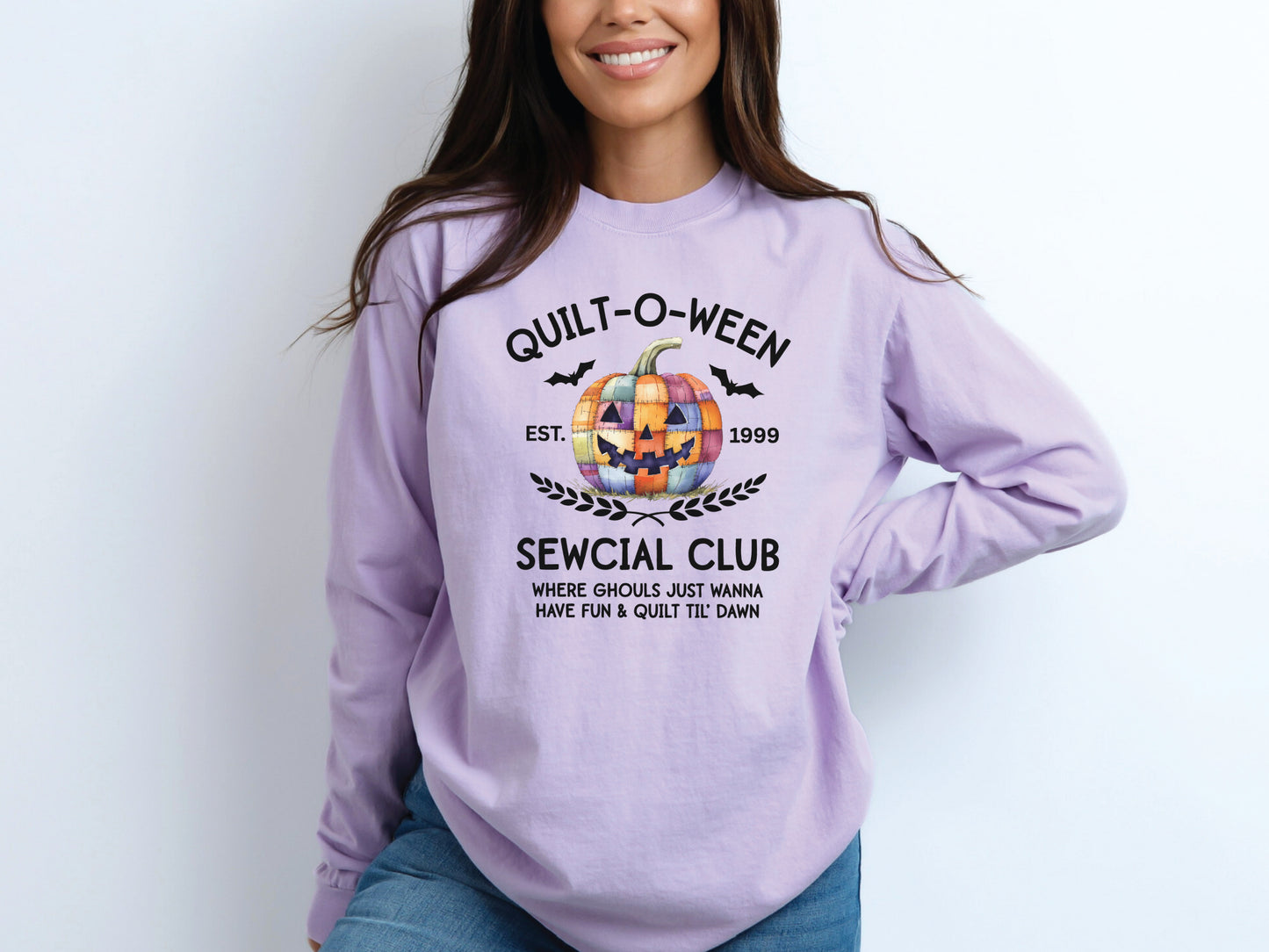Quilt-O-Ween Sewcial Club long sleeve Lt. Purple (Orchid)shirt from Bee Inspired Tees, featuring a colorful patchwork jack-o’-lantern, bats, and playful Halloween typography—fun gift for quilters.