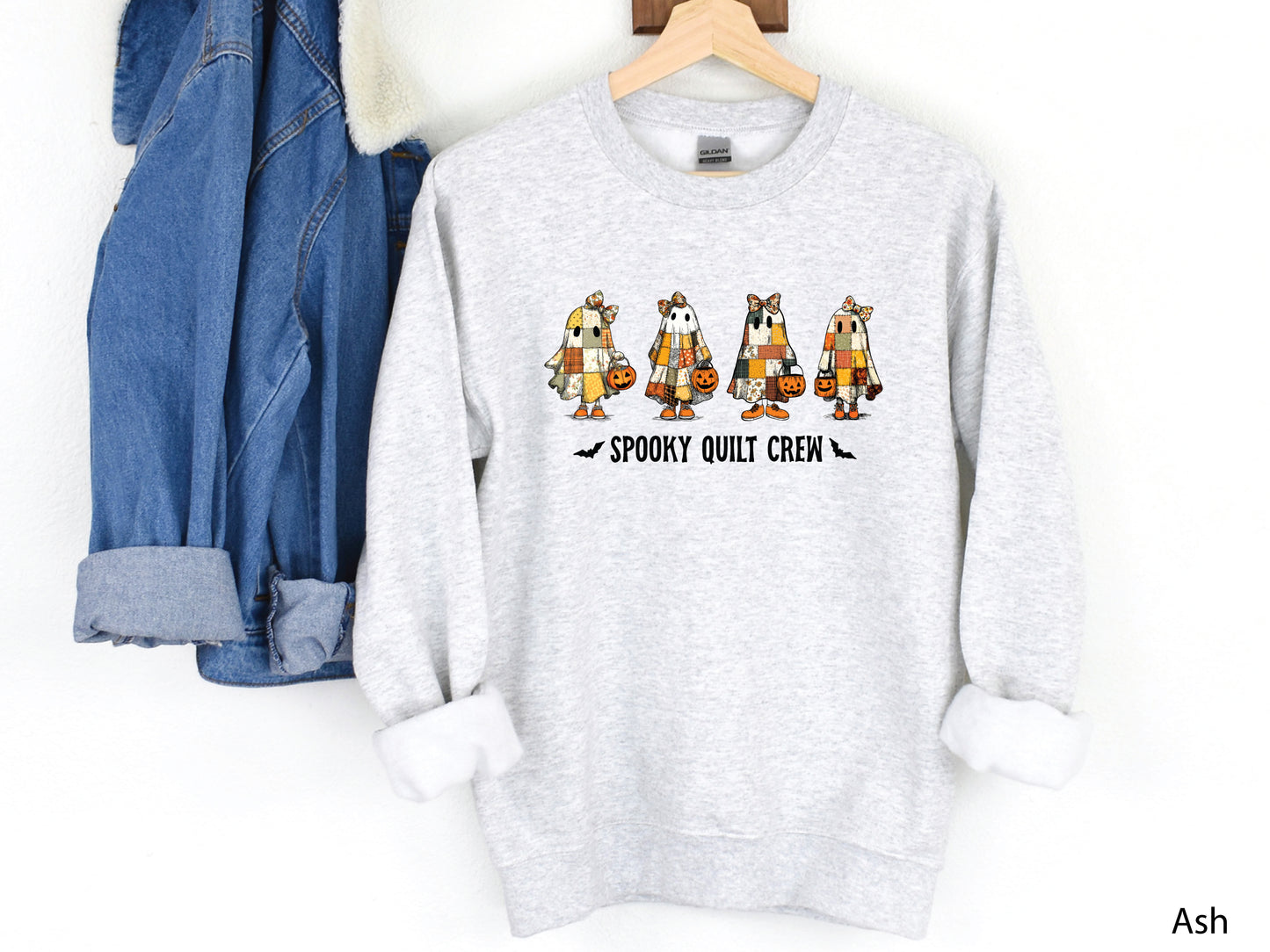 Spooky Quilt Crew sweatshirt from Bee Inspired Tees in the color Ash, featuring four patchwork ghosts with jack-o’-lanterns and bold text—fun Halloween gift for quilters.