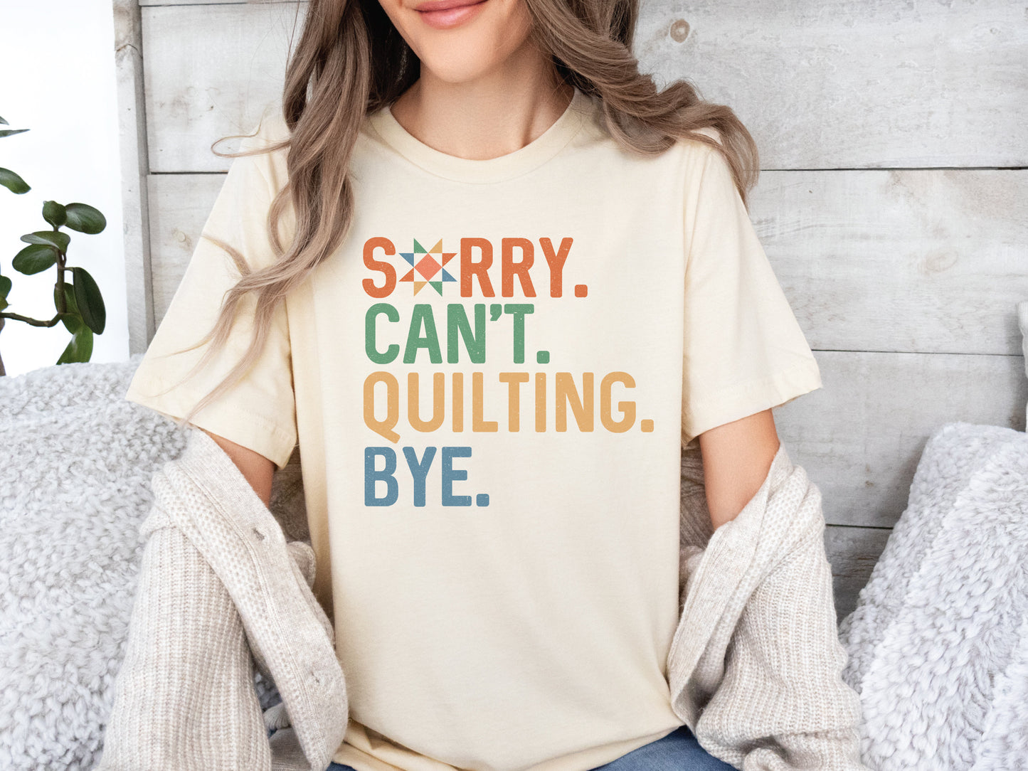 The (distressed style) text on this ladies t-shirt reads Sorry Cant Quilting Bye. Each word has a colorful color text (Orange, Green, Yellow and Blue). Quilt star in the O in Sorry.