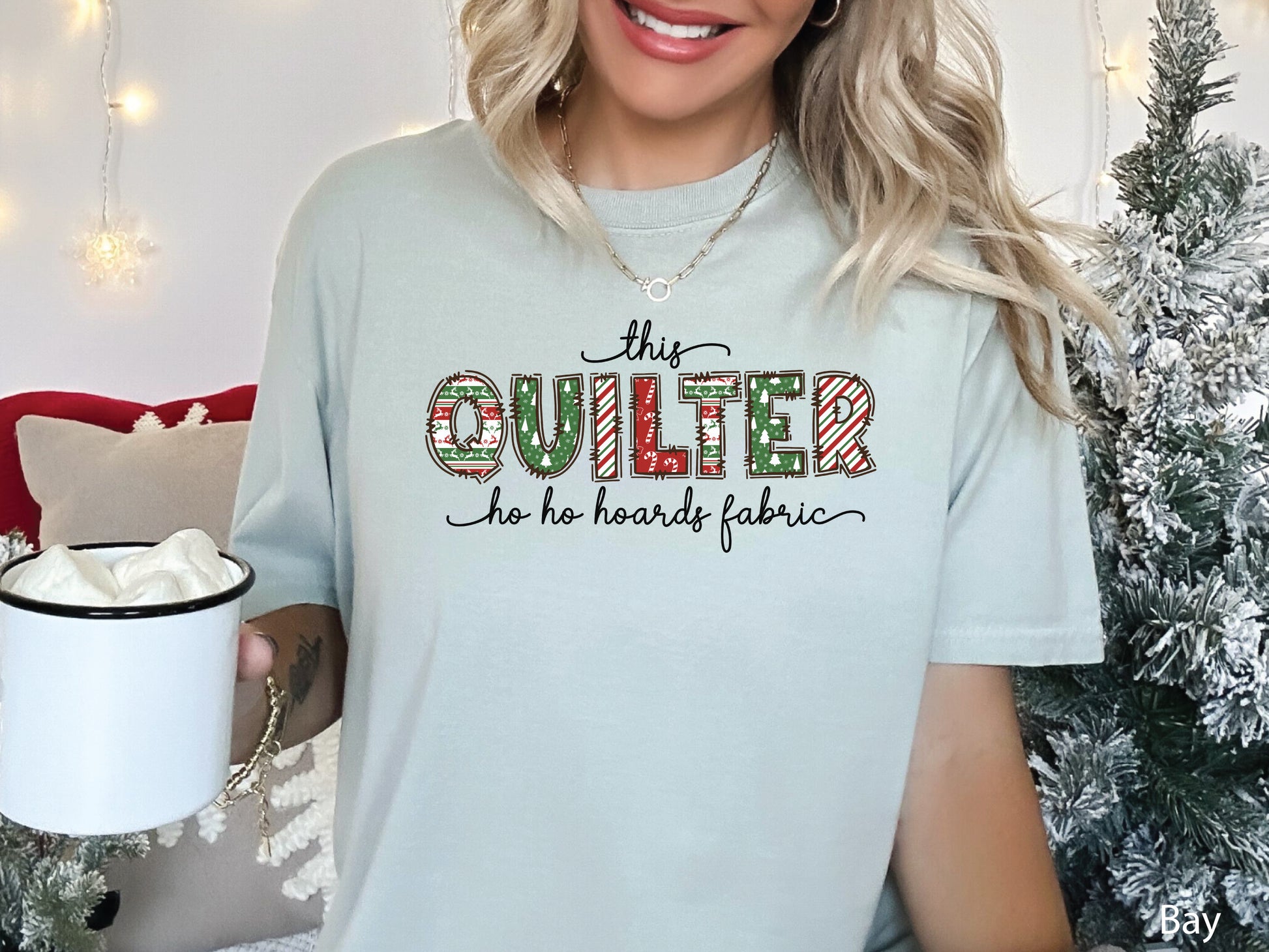 This Quilter Ho Ho Hoards Fabric t-shirt with red and green patchwork lettering, a funny Christmas shirt for quilters who love fabric, sewing, and holiday cheer.