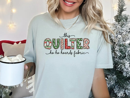 This Quilter Ho Ho Hoards Fabric t-shirt with red and green patchwork lettering, a funny Christmas shirt for quilters who love fabric, sewing, and holiday cheer.