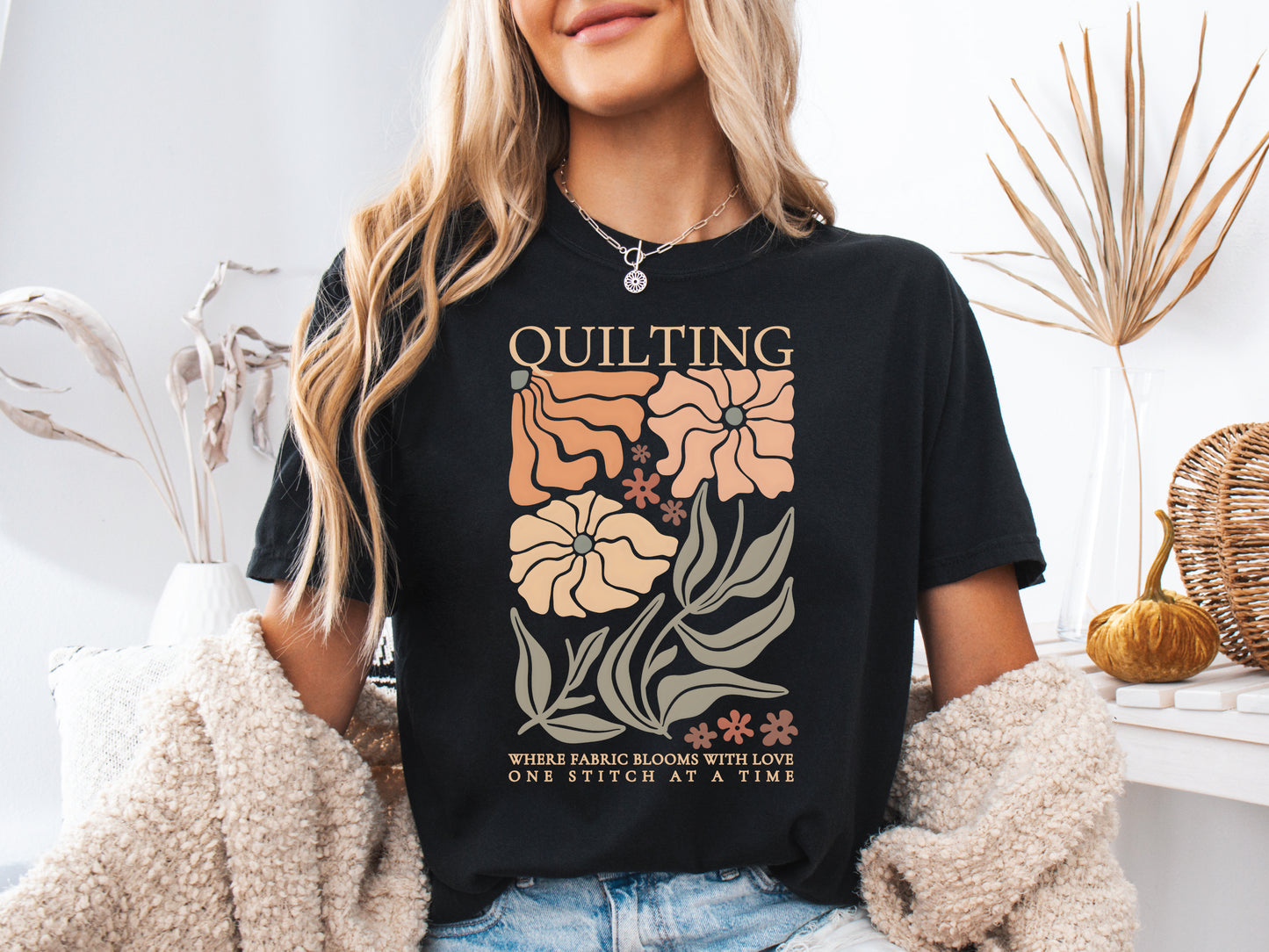 Boho quilting short sleeve t-shirt featuring a floral design and the phrase “Quilting, Where Fabric Blooms With Love, One Stitch at a Time.” 