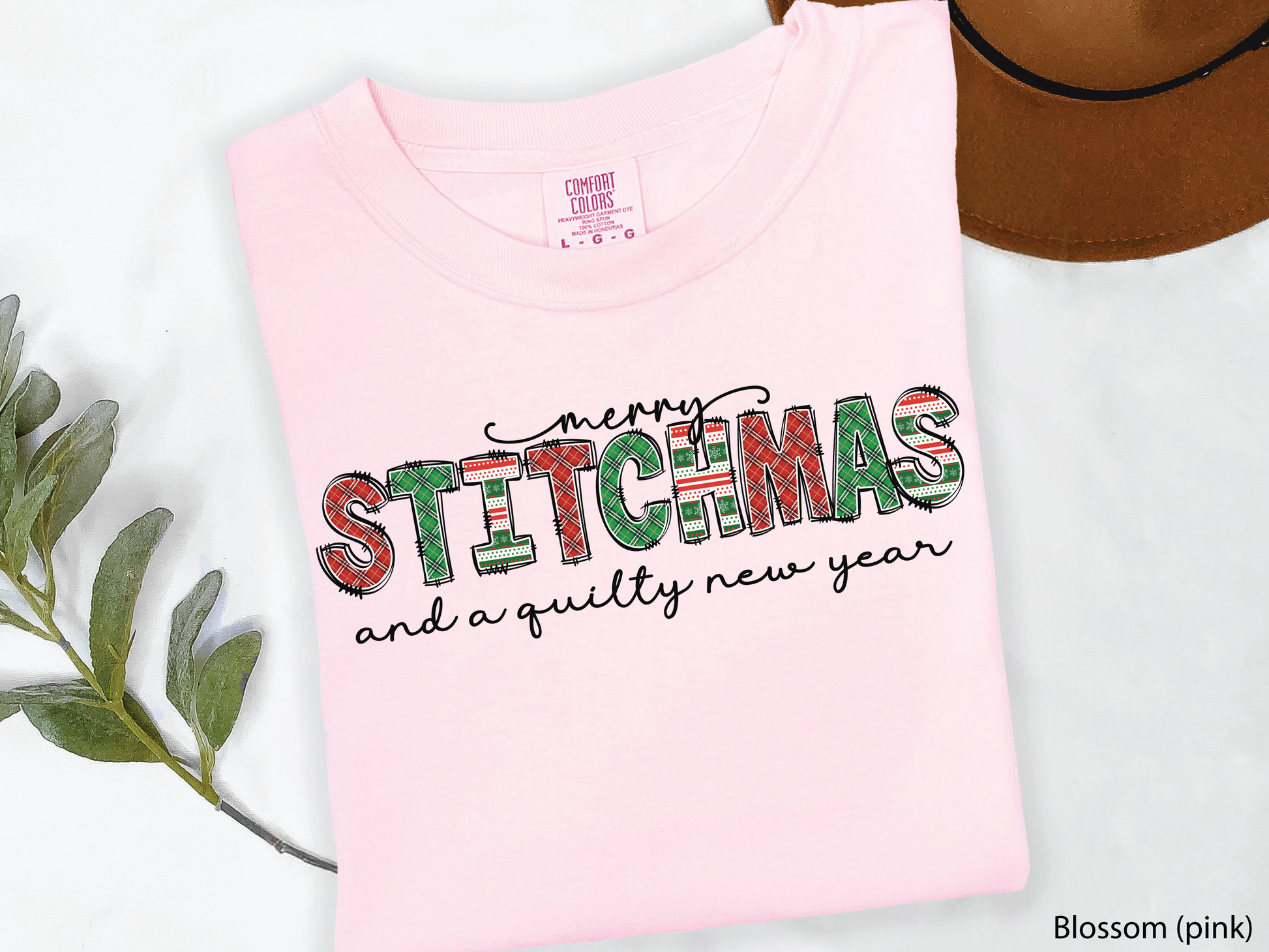 Festive Merry Stitchmas & a Quilty New Year t-shirt with red, green patchwork lettering—perfect holiday gift for quilters and sewists.