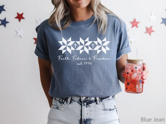 Blue t-shirt with Faith, Fabric & Freedom design featuring quilt star blocks with cross details, ideal for quilters and faith-based patriotic wear.