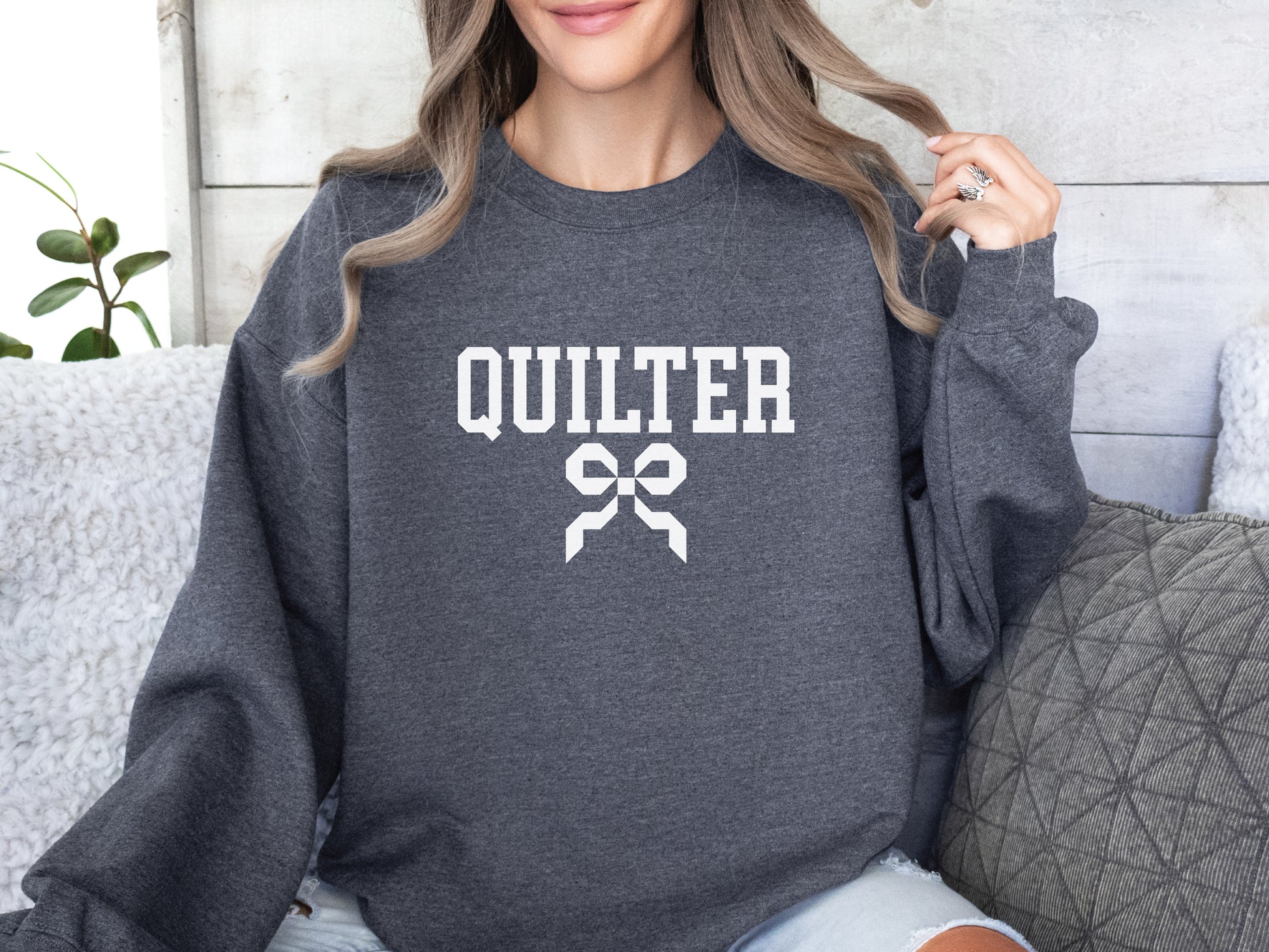 Quilter sweatshirt with varsity-style lettering and a quilty coquette bow, a cozy and stylish gift for quilters to wear at retreats, guilds, or while sewing at home.