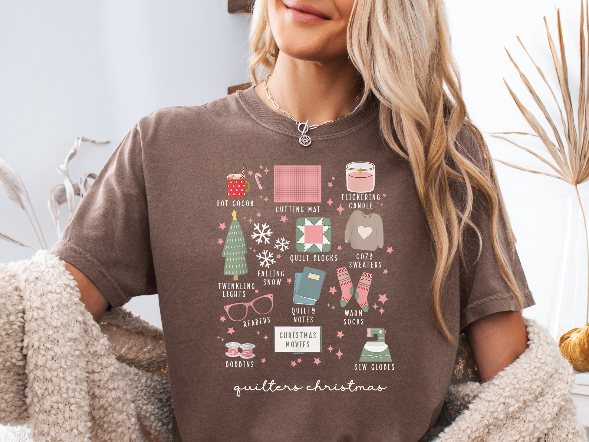 T-shirt with festive “Quilter’s Christmas” icons including quilt blocks, cocoa, lights, sweaters, and sewing items — perfect holiday gift for quilters and sewing lovers.