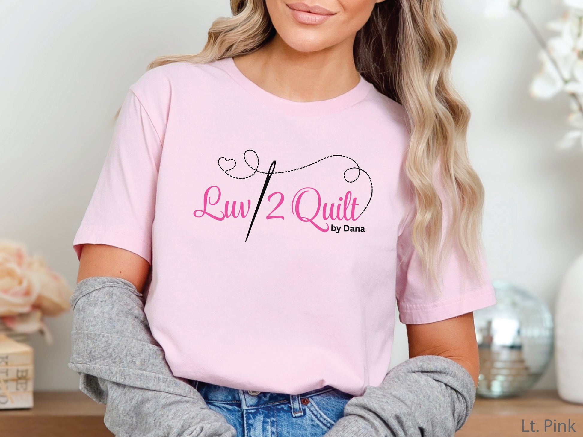 Official Luv2Quilt by Dana quilting-themed t-shirt featuring the Luv2Quilt logo with a sewing needle and stitched heart design, perfect for quilt classes, retreats, and everyday wear.