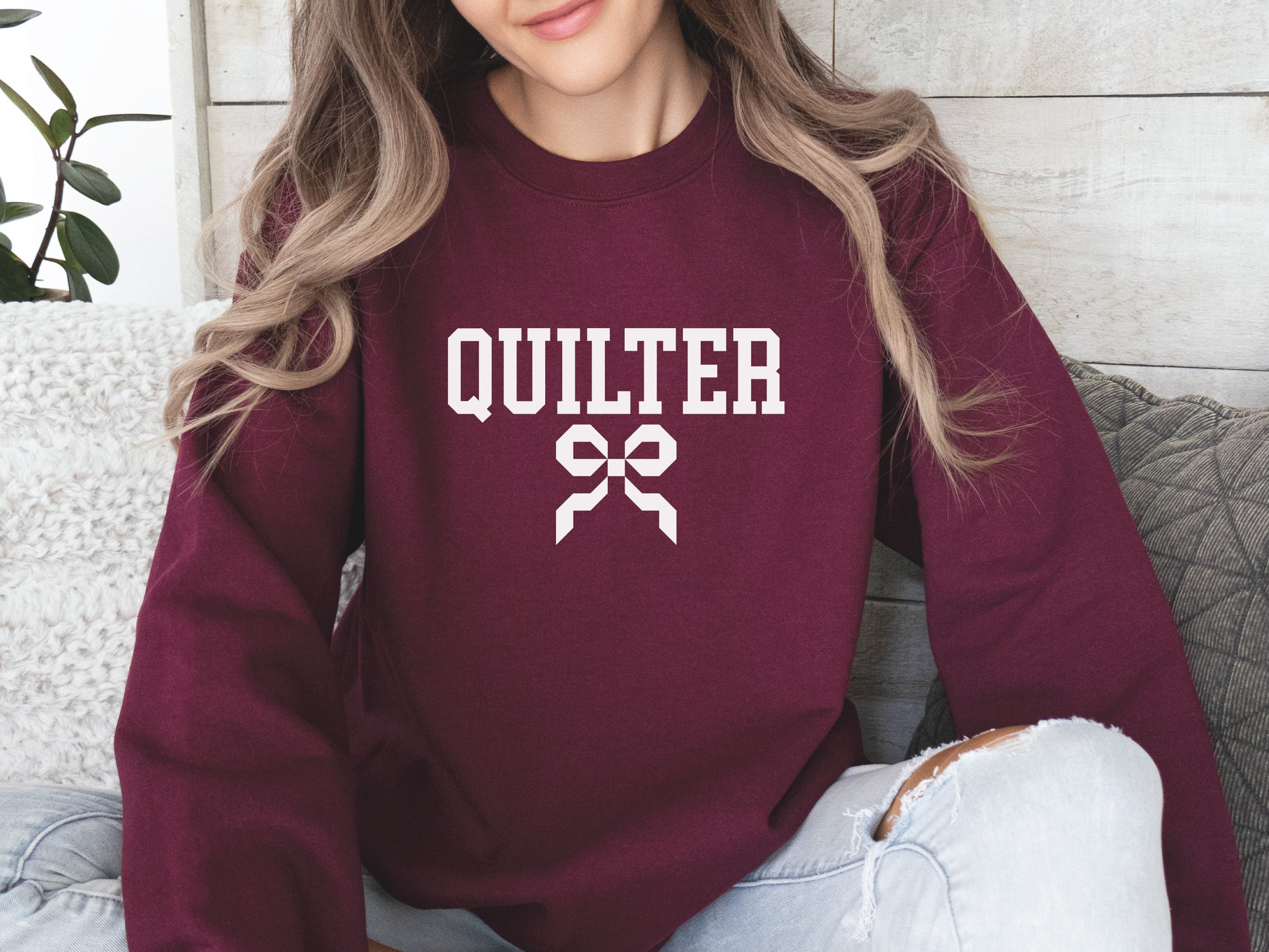 Quilter sweatshirt with varsity-style lettering and a quilty coquette bow, a cozy and stylish gift for quilters to wear at retreats, guilds, or while sewing at home.
