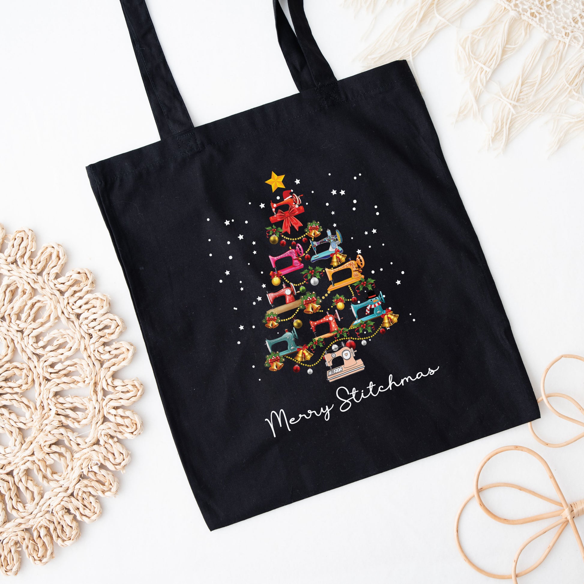 Black canvas tote bag featuring a festive Christmas tree made of sewing machines printed on both sides. A holiday gift for quilters and sewers from Bee Inspired Tees, perfect for quilt retreats, sewing classes, and everyday use.