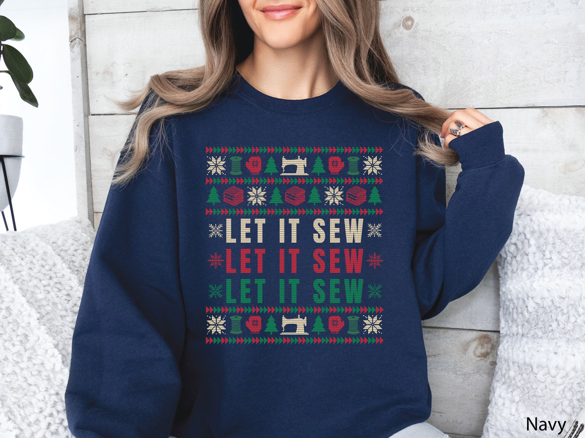 Navy Christmas sweatshirt featuring a colorful knitted-style Let It Sew design with sewing machines, thread spools, fabric stacks, snowflakes, Christmas trees, and red and green quilt-inspired borders.