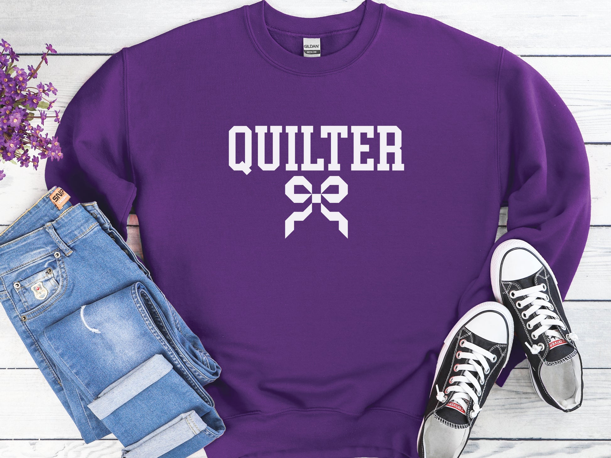 Quilter sweatshirt with varsity-style lettering and a quilty coquette bow, a cozy and stylish gift for quilters to wear at retreats, guilds, or while sewing at home.