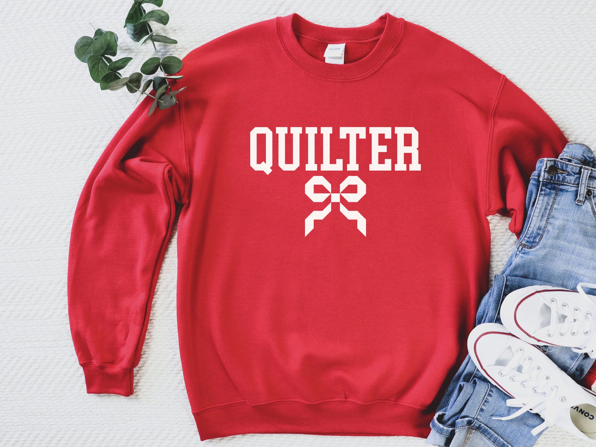 Quilter sweatshirt with varsity-style lettering and a quilty coquette bow, a cozy and stylish gift for quilters to wear at retreats, guilds, or while sewing at home.