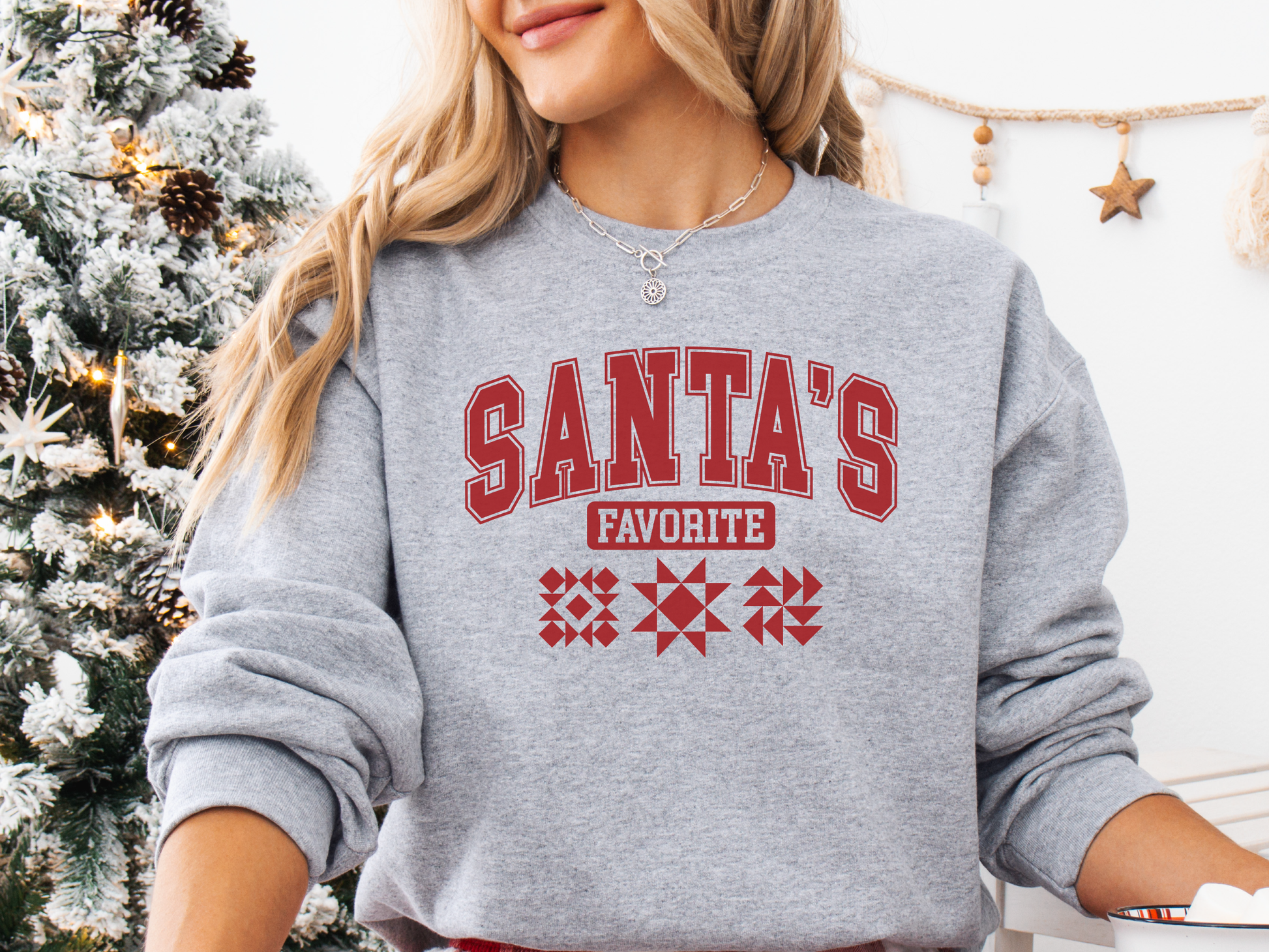 Cozy Sport Grey colored Christmas sweatshirt with the phrase “Santa’s Favorite” in bold red varsity letters and three quilt block designs, perfect for quilters celebrating the holidays in handmade style.