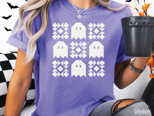 Halloween quilt t-shirt in Comfort Colors Violet orange with spooky ghost quilt blocks in a grid design—fun fall gift for quilters.