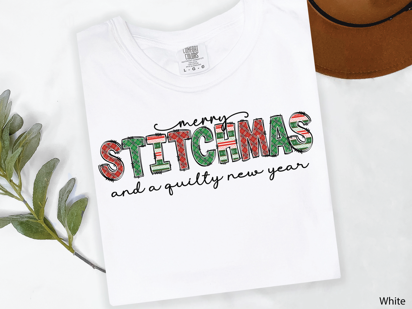 Festive Merry Stitchmas & a Quilty New Year t-shirt with red, green patchwork lettering—perfect holiday gift for quilters and sewists.
