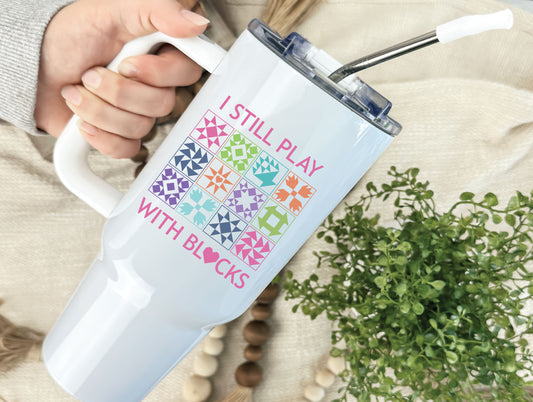 40oz tumbler with “I Still Play With Blocks,” decorated with colorful quilt blocks and a quilt-heart design; comes individually boxed for gifting.