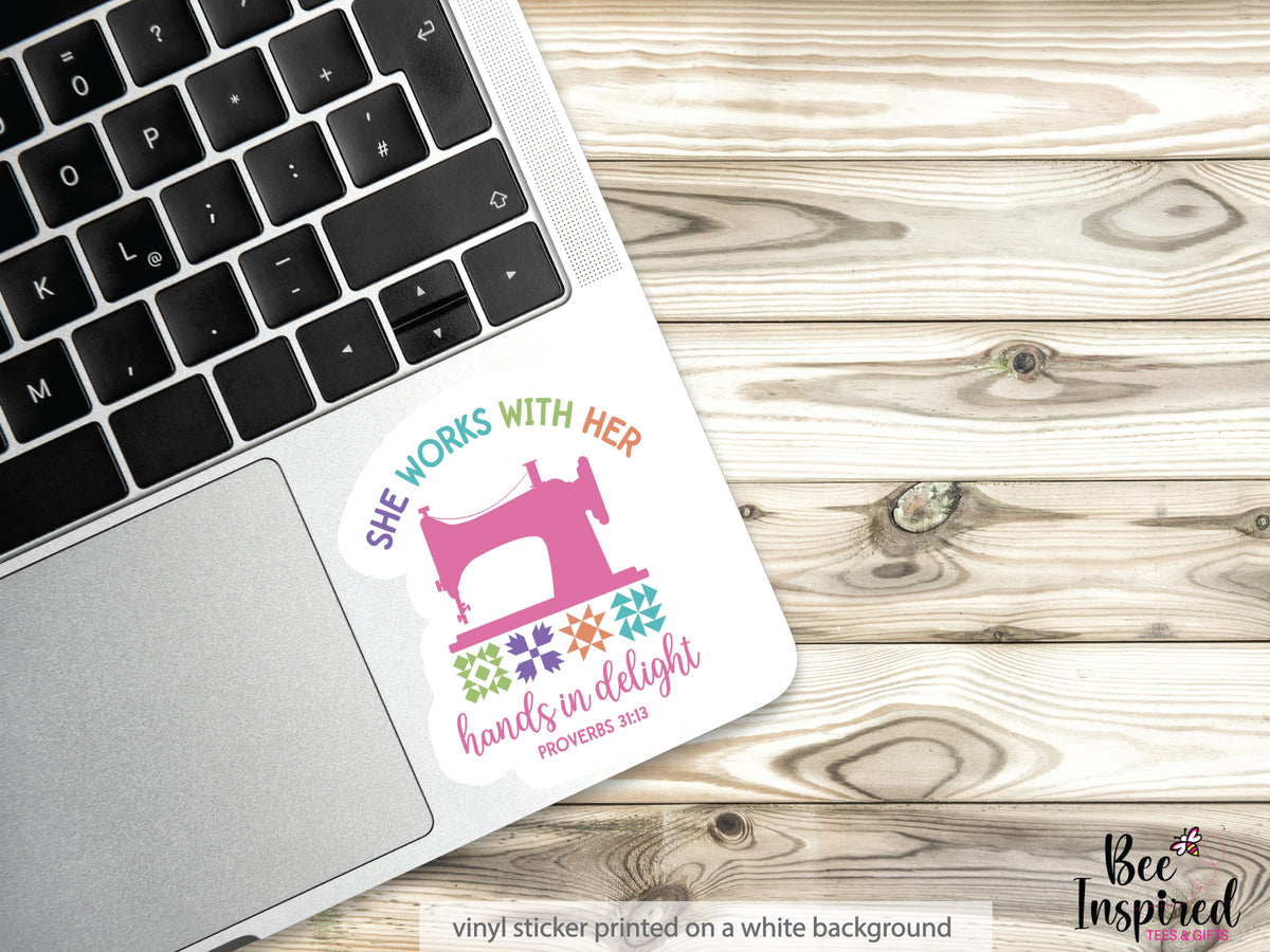 She Works With Her Hands vinyl sticker featuring a vintage sewing machine, colorful quilt blocks, and the inspirational Proverbs 31:13 verse.
