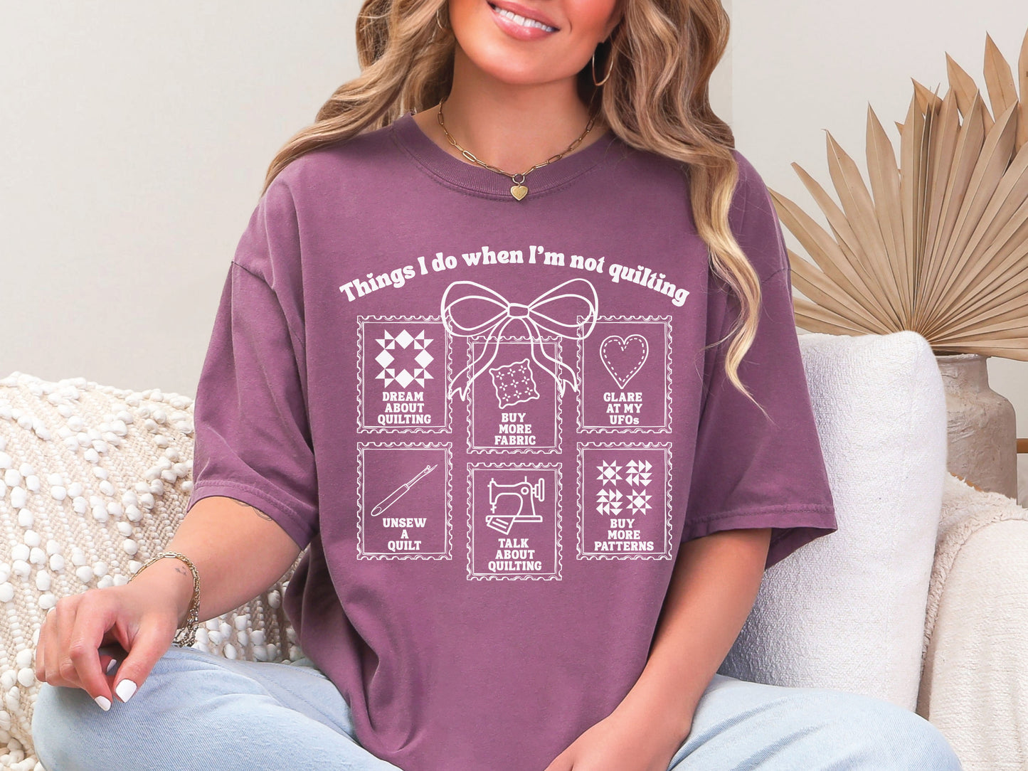 A soft, and cozy t-shirt featuring the phrase “Things I Do When I’m Not Quilting” with stitched-style icons showing humorous quilting activities like buying fabric, dreaming of quilts, and unsewing.