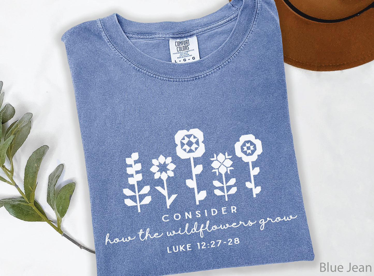 Quilt-inspired wildflower design t-shirt featuring Bible verse Luke 12:27–28, perfect for quilters and faith-based apparel.