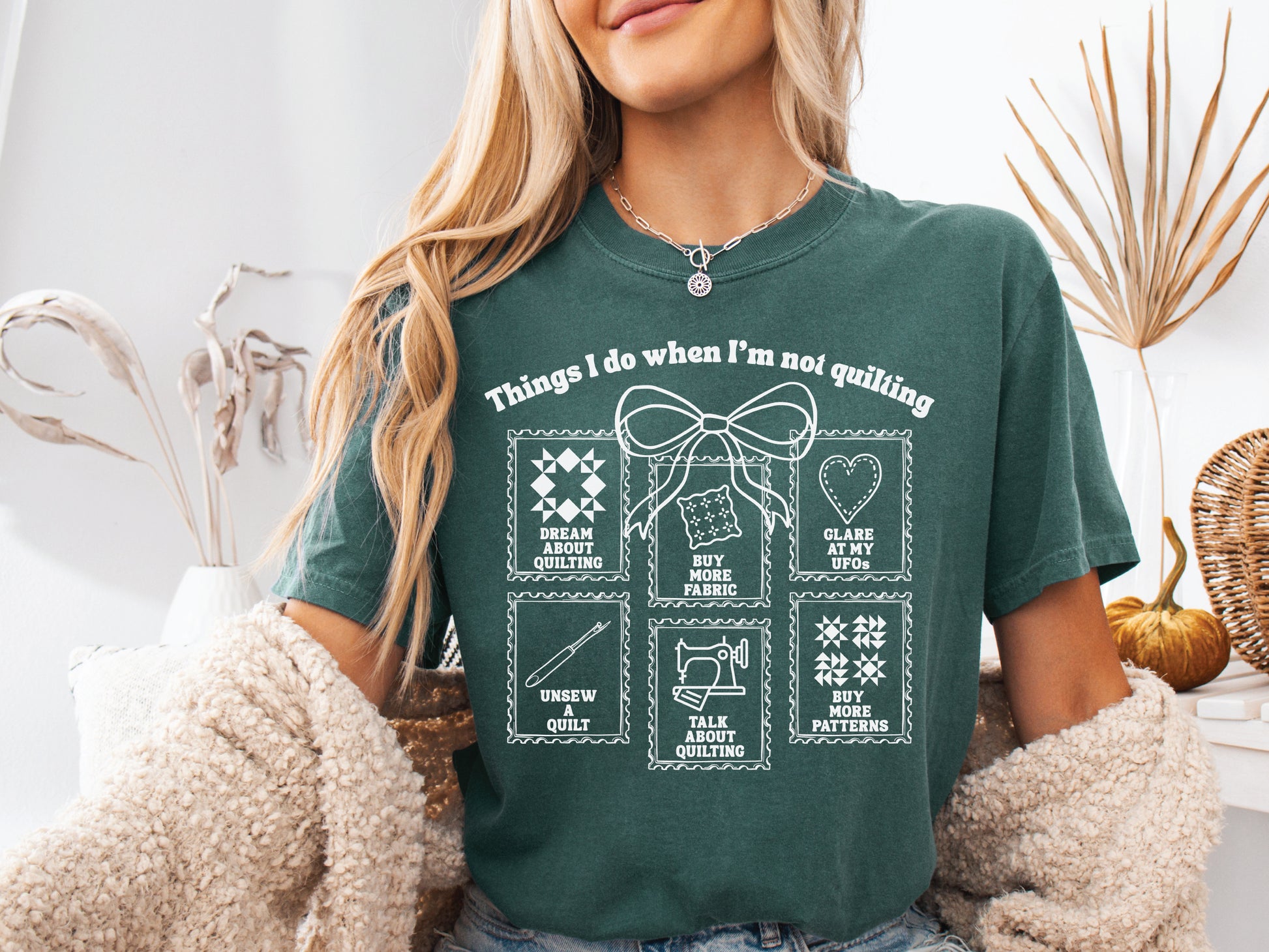 A soft, and cozy t-shirt featuring the phrase “Things I Do When I’m Not Quilting” with stitched-style icons showing humorous quilting activities like buying fabric, dreaming of quilts, and unsewing.