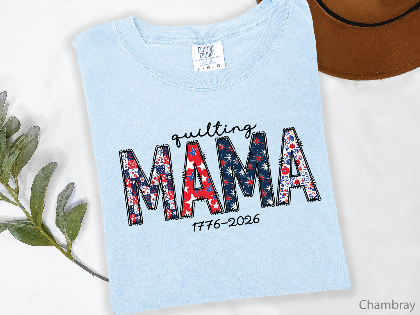 White t-shirt with Quilting Mama design in red, white, and blue patchwork lettering with stitched details, perfect for quilters and Mother’s Day gifts.
