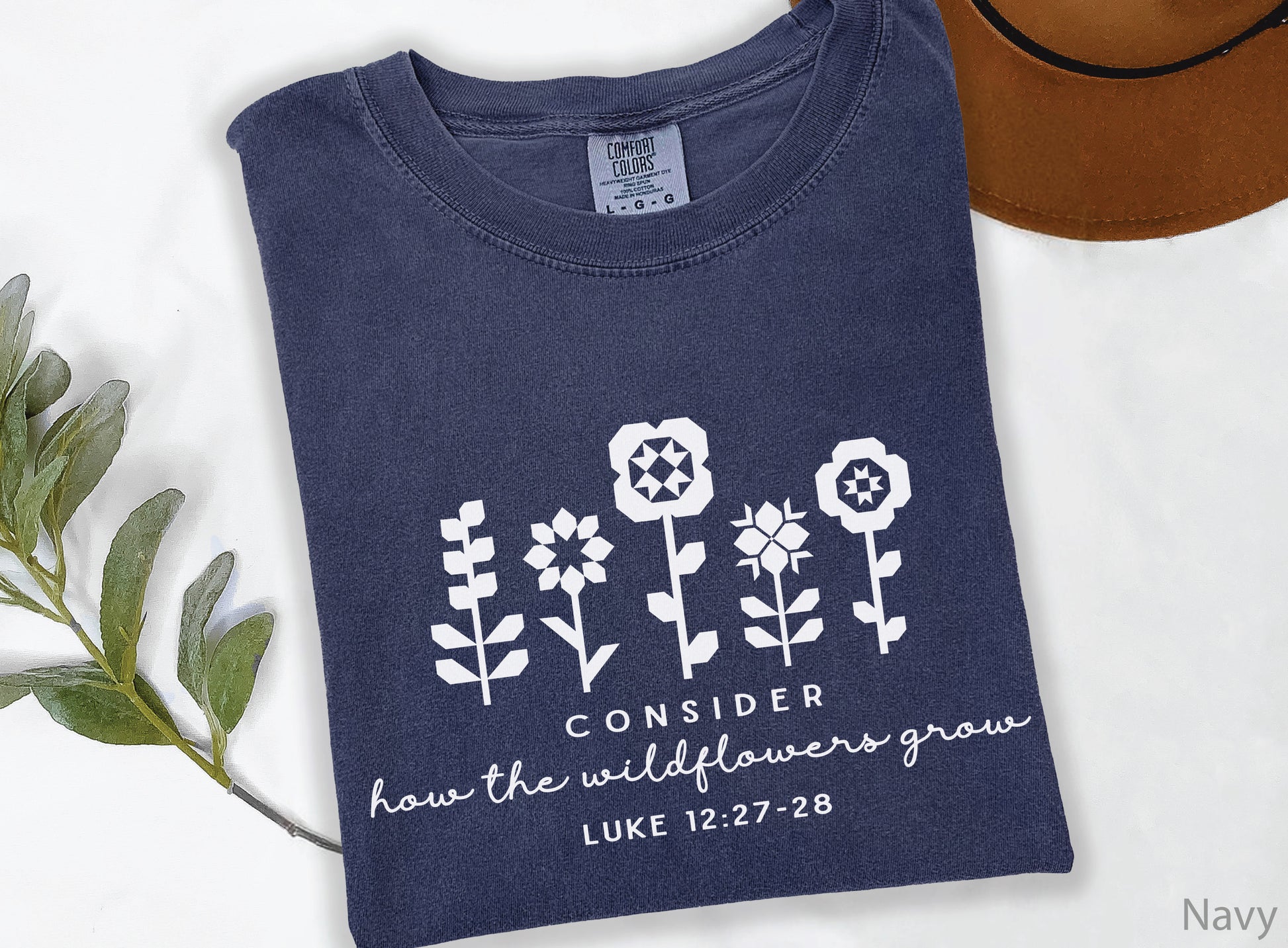 Quilt-inspired wildflower design t-shirt featuring Bible verse Luke 12:27–28, perfect for quilters and faith-based apparel.