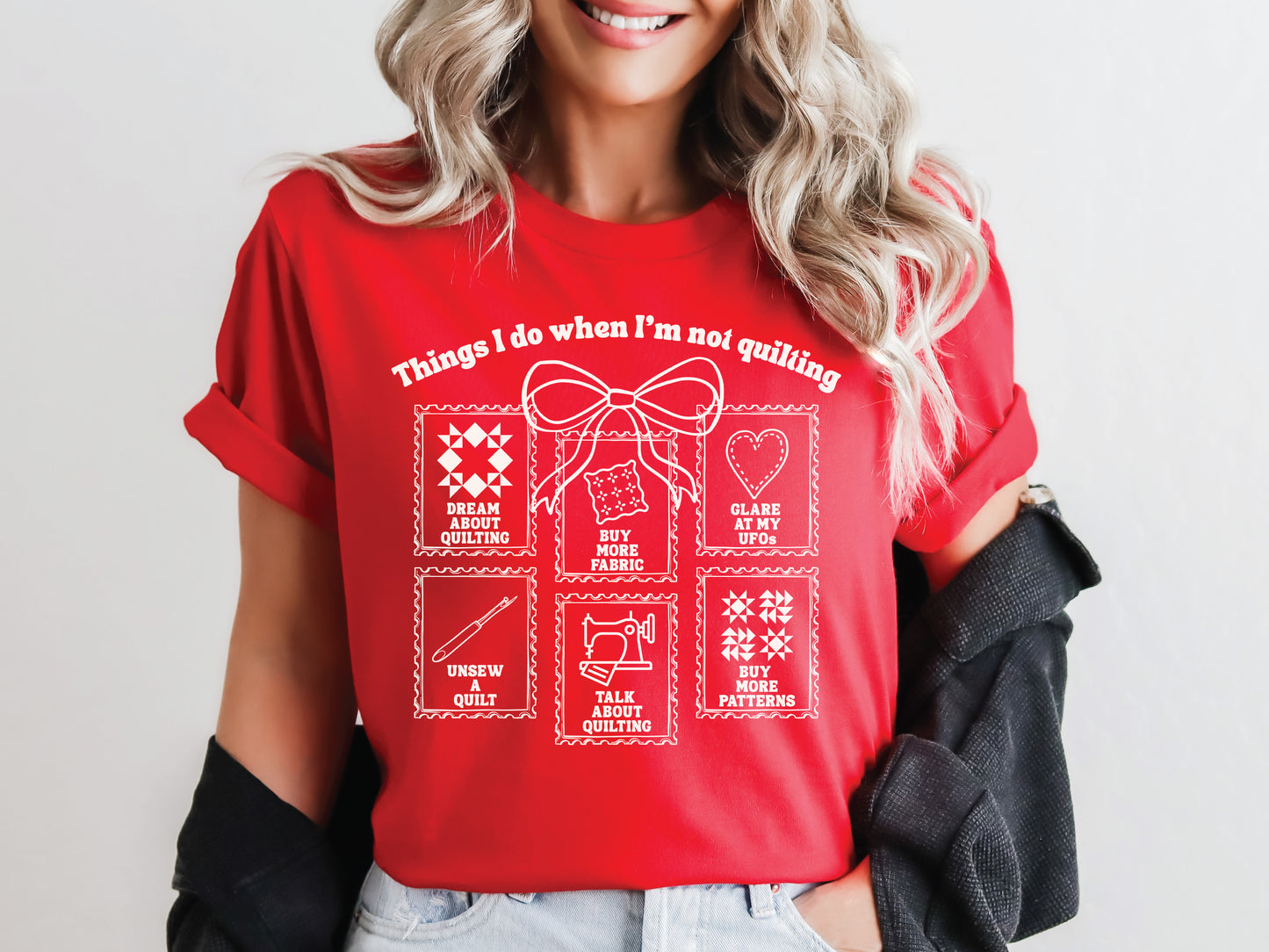 A soft, and cozy t-shirt featuring the phrase “Things I Do When I’m Not Quilting” with stitched-style icons showing humorous quilting activities like buying fabric, dreaming of quilts, and unsewing.