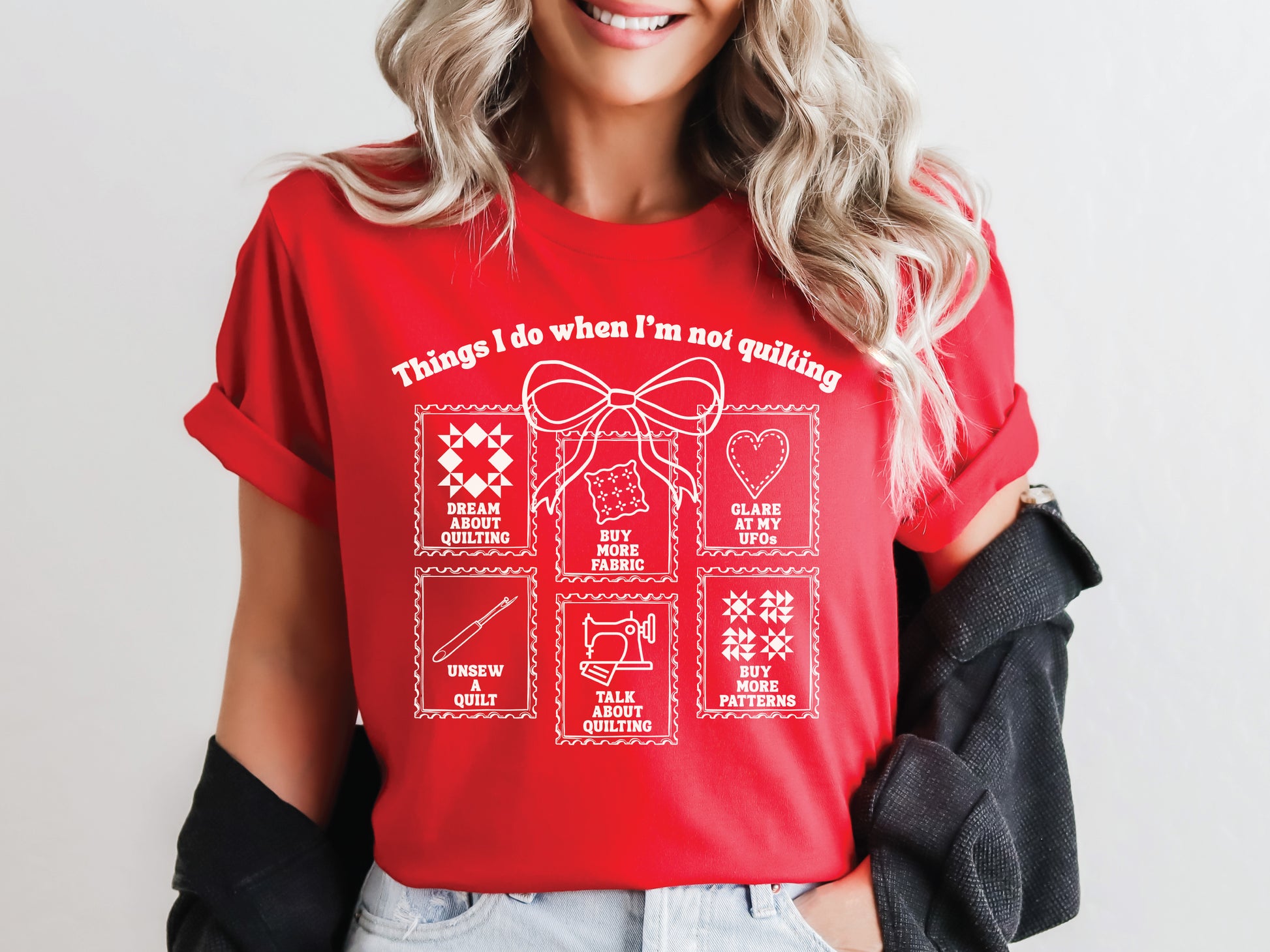 A soft, and cozy t-shirt featuring the phrase “Things I Do When I’m Not Quilting” with stitched-style icons showing humorous quilting activities like buying fabric, dreaming of quilts, and unsewing.