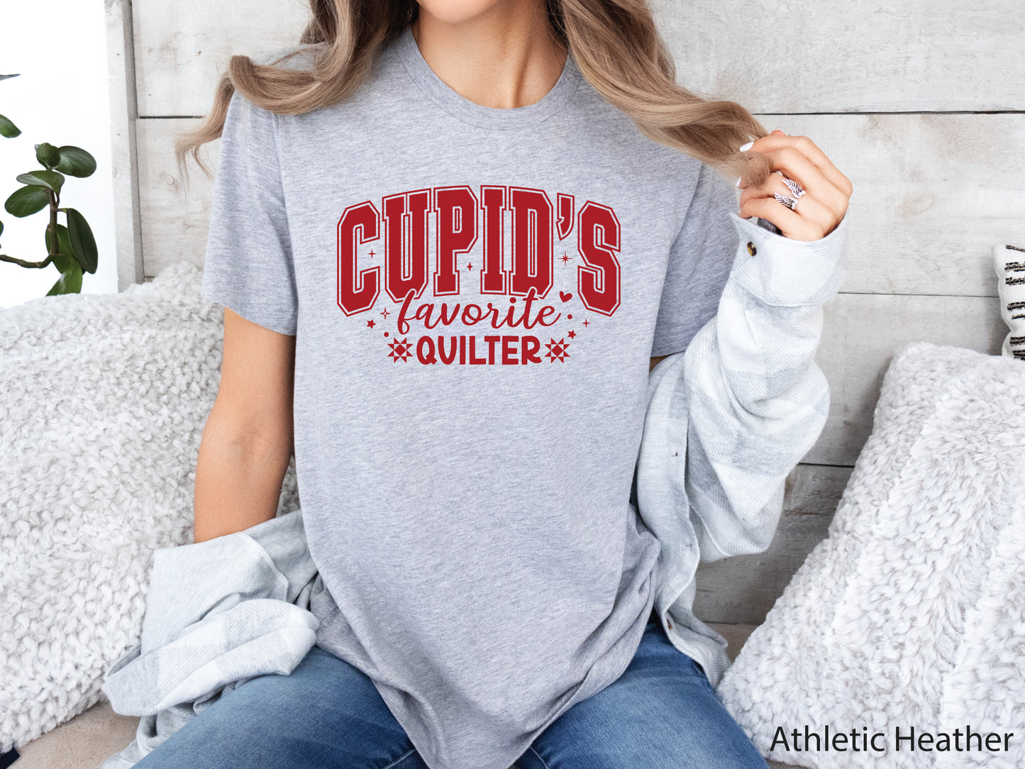 Valentine’s Day quilting t-shirt with “Cupid’s Favorite Quilter” phrase in varsity-style lettering and quilt-inspired details, perfect for quilters.