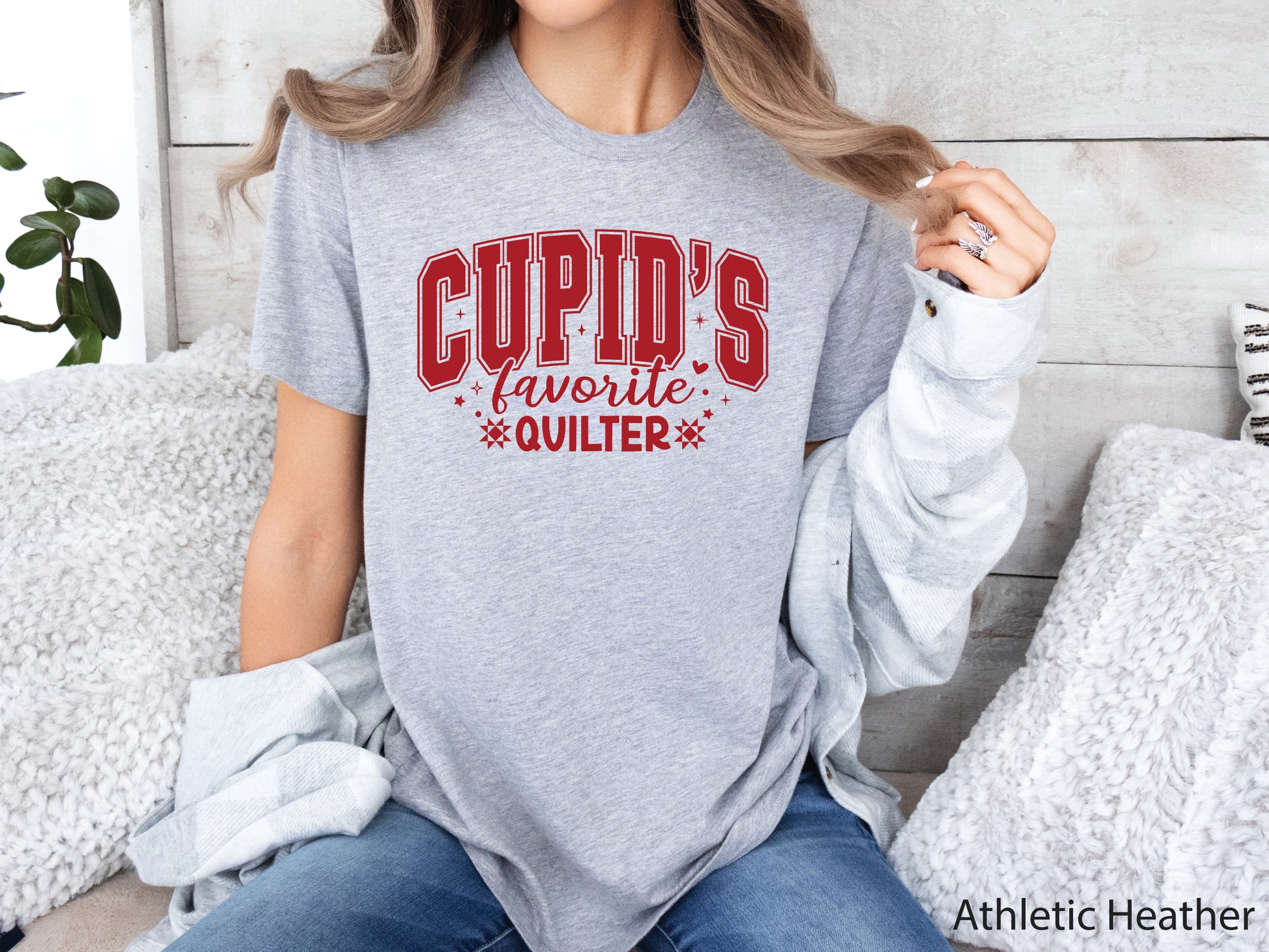 Valentine’s Day quilting t-shirt with “Cupid’s Favorite Quilter” phrase in varsity-style lettering and quilt-inspired details, perfect for quilters.