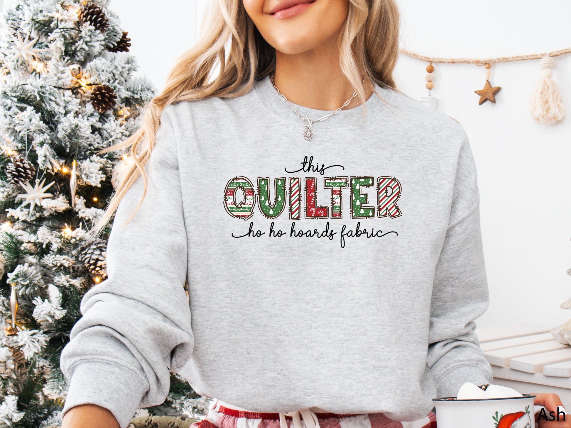Cozy sweatshirt with playful patchwork lettering that says “This Quilter Ho Ho Hoards Fabric” — festive Christmas gift for quilters and sewing enthusiasts.