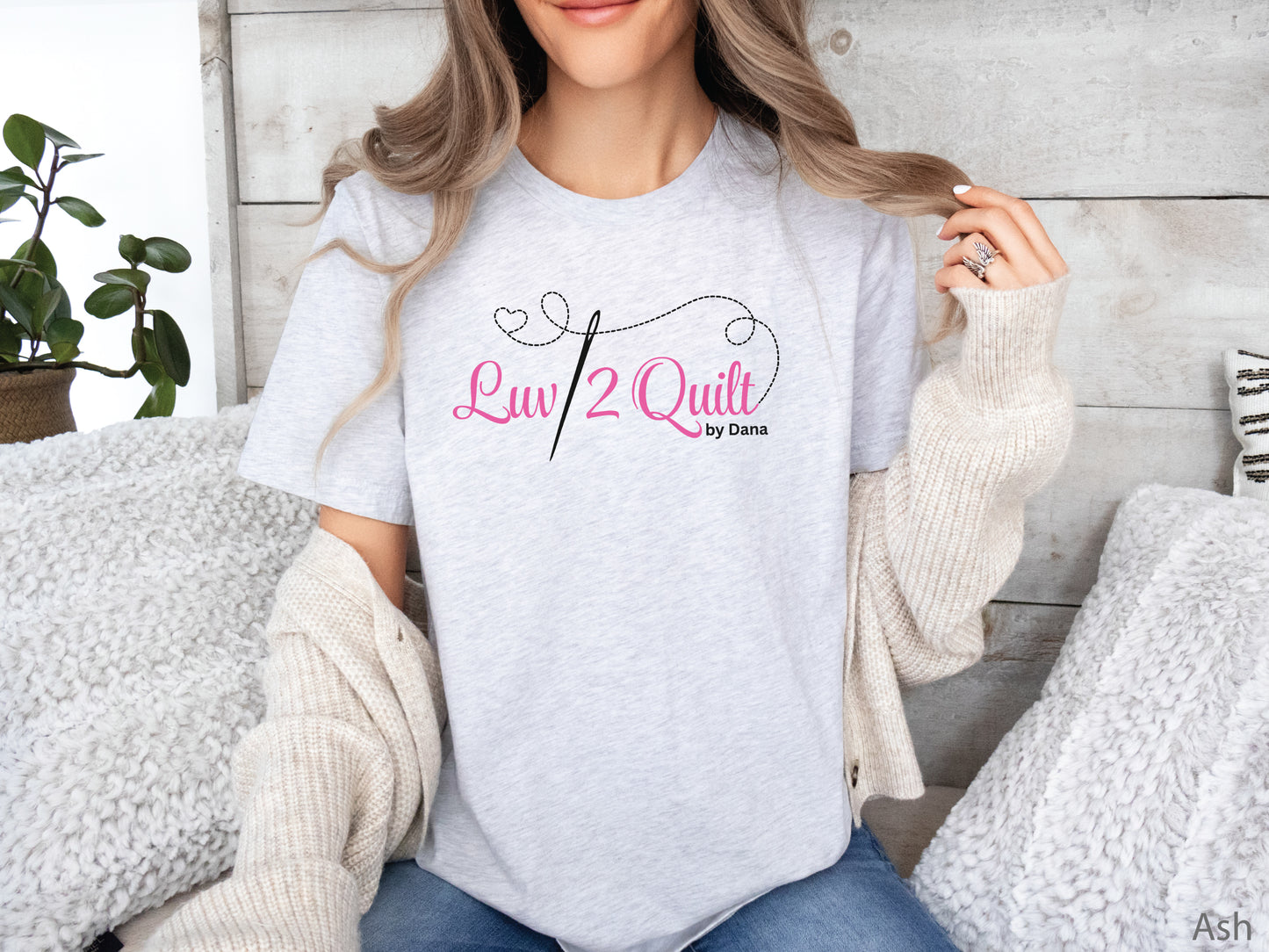 Official Luv2Quilt by Dana quilting-themed t-shirt featuring the Luv2Quilt logo with a sewing needle and stitched heart design, perfect for quilt classes, retreats, and everyday wear.