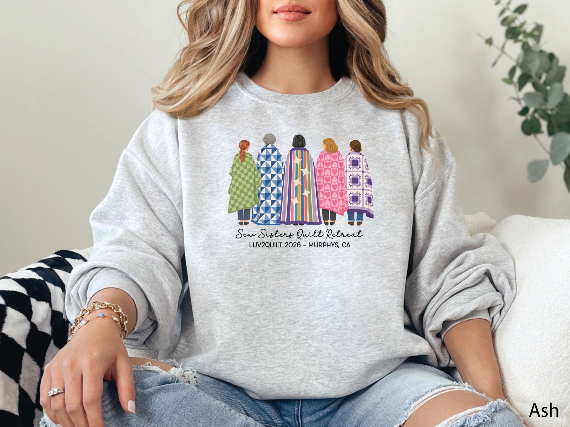Sew Sisters Quilt Retreat shirt design featuring five women wrapped in colorful green, blue, striped, pink heart, and purple quilts with LUV2QUILT 2026 – Murphys, CA text.