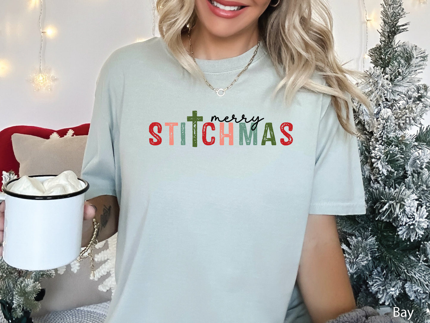 Merry Stitchmas t-shirt featuring the word STITCHMAS with a cross-shaped T, a festive holiday design for quilters, sewists, and makers who love stitching and faith.