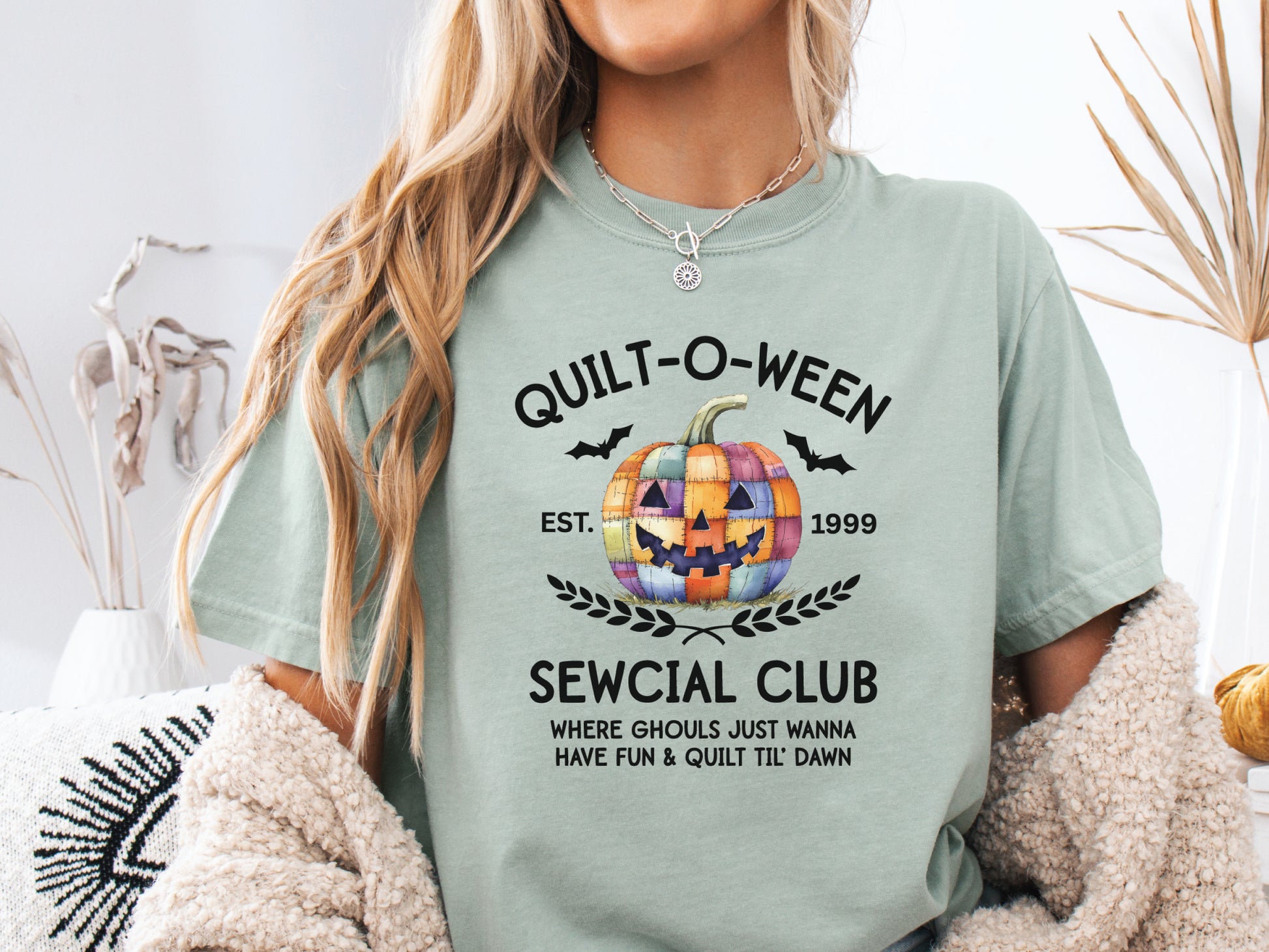 Quilt-O-Ween Sewcial Club shirt from Bee Inspired Tees, designed in Lt.Green (Bay) with a colorful patchwork jack-o’-lantern, bats, and playful Halloween typography—perfect gift for quilters.