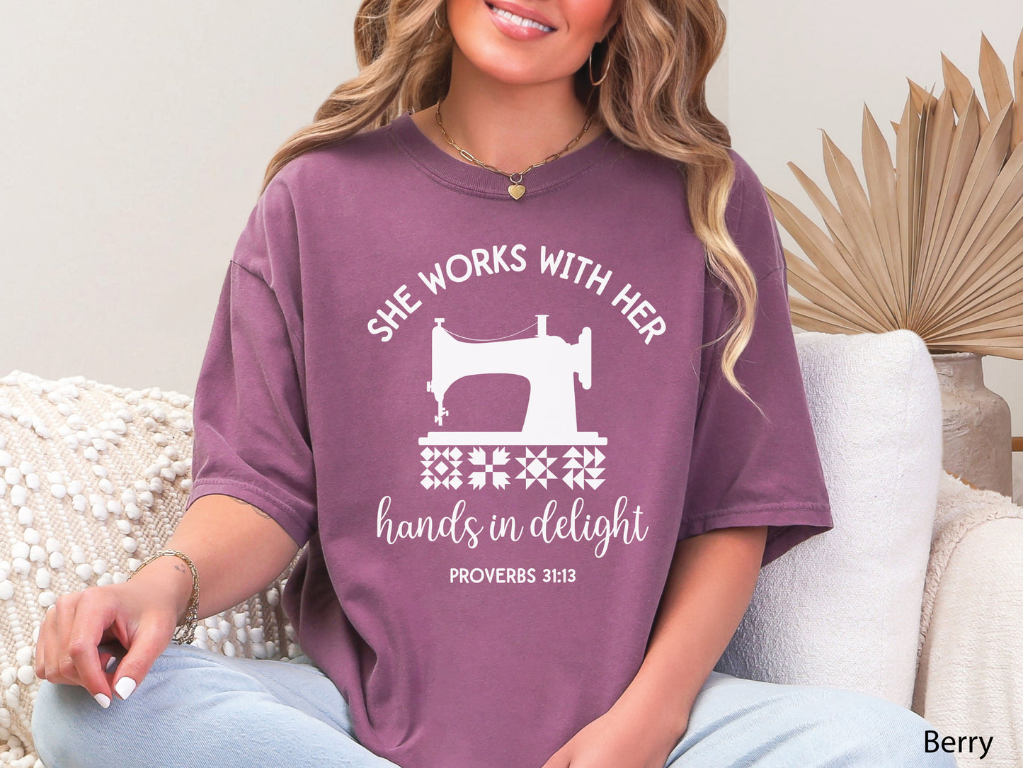 A t-shirt featuring a vintage-style sewing machine, quilt block icons, and the verse “She works with her hands in delight – Proverbs 31:13.”