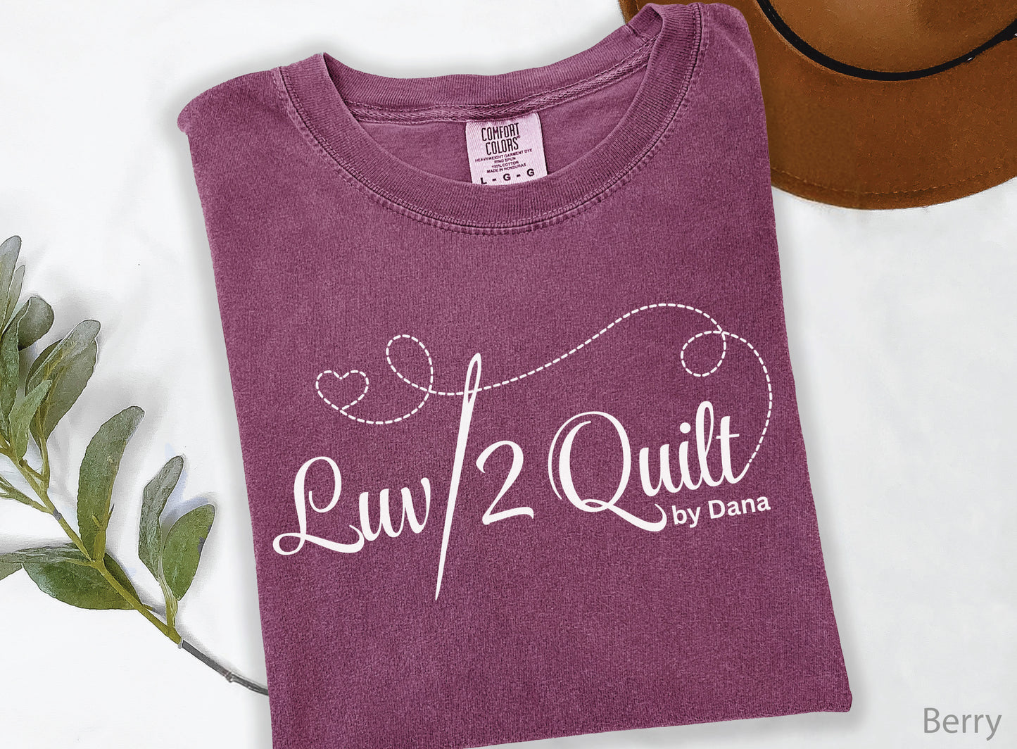Official Luv2Quilt by Dana quilting-themed t-shirt featuring the Luv2Quilt logo with a sewing needle and stitched heart design, perfect for quilt classes, retreats, and everyday wear.