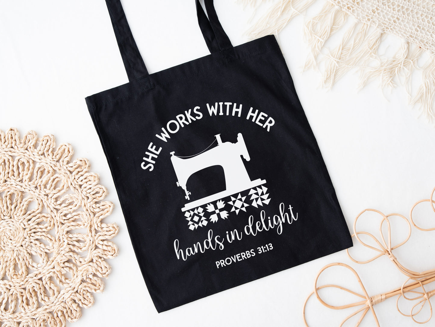 Inspiring quilting  canvas tote bag with a vintage sewing machine, quilt block icons, and the verse “She works with her hands in delight – Proverbs 31:13.” A meaningful faith-based gift.