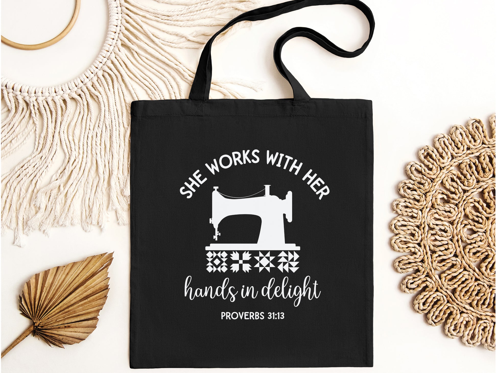 Inspiring quilting  canvas tote bag with a vintage sewing machine, quilt block icons, and the verse “She works with her hands in delight – Proverbs 31:13.” A meaningful faith-based gift.