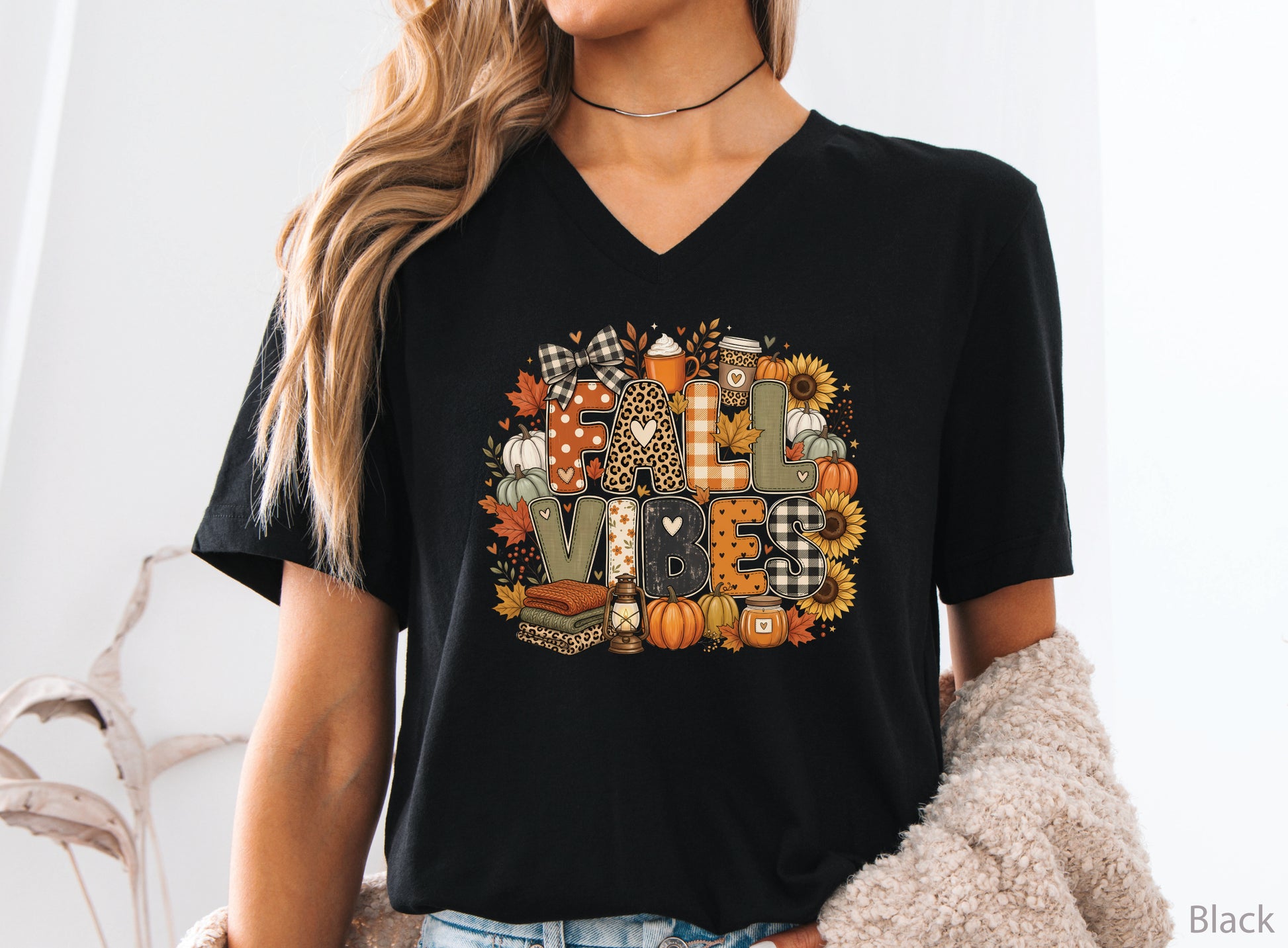 Fall Vibes t-shirt design with patchwork-style lettering, pumpkins, sunflowers, fall leaves, cozy drinks, lantern, candle, and folded blankets.
