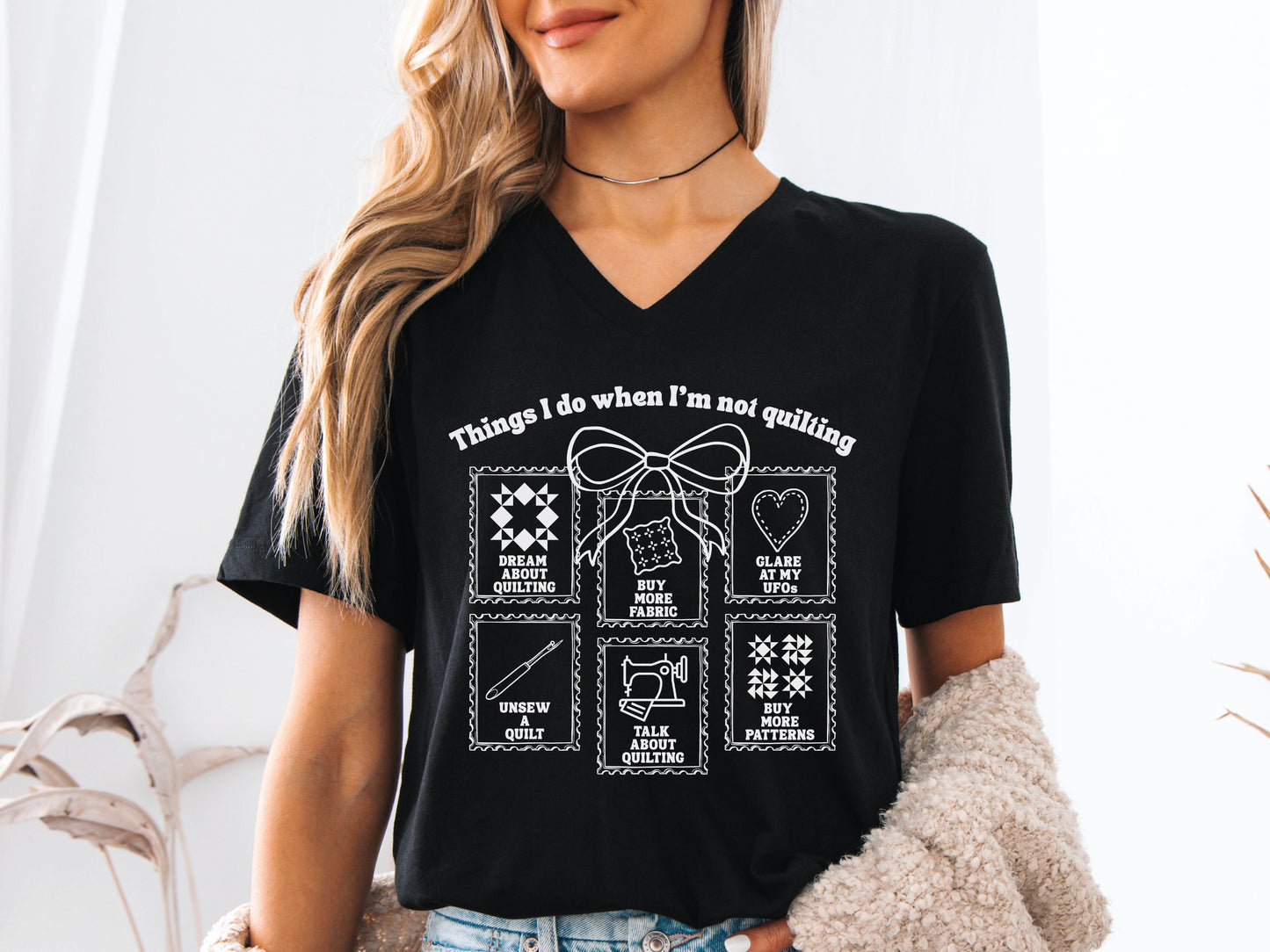 Quilting V-neck t-shirt with “Things I Do When I’m Not Quilting” phrase and stitched-style icons, perfect gift for quilters and sewing enthusiasts.