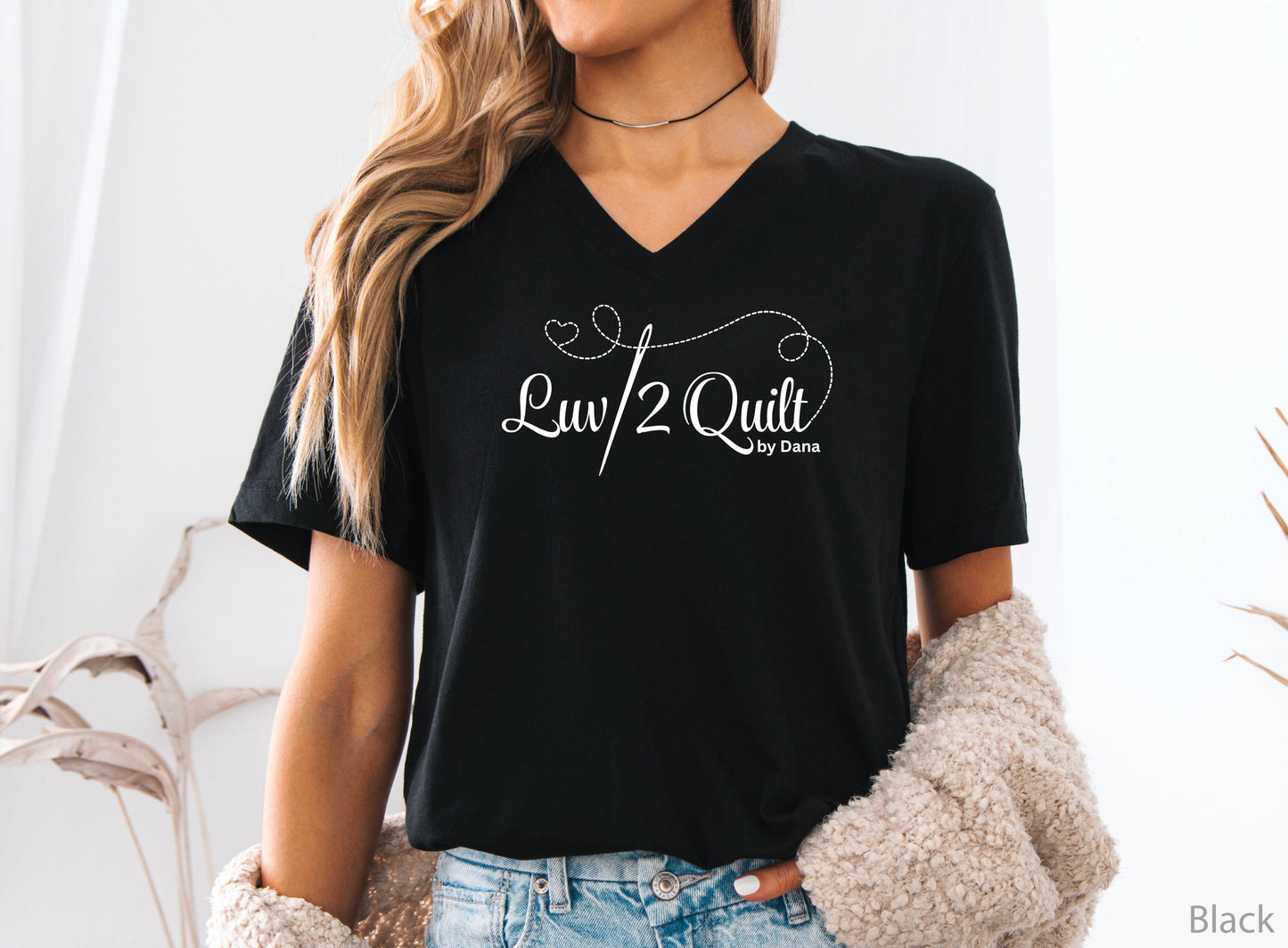 Official Luv2Quilt by Dana quilting-themed t-shirt featuring the Luv2Quilt logo with a sewing needle and stitched heart design, perfect for quilt classes, retreats, and everyday wear.