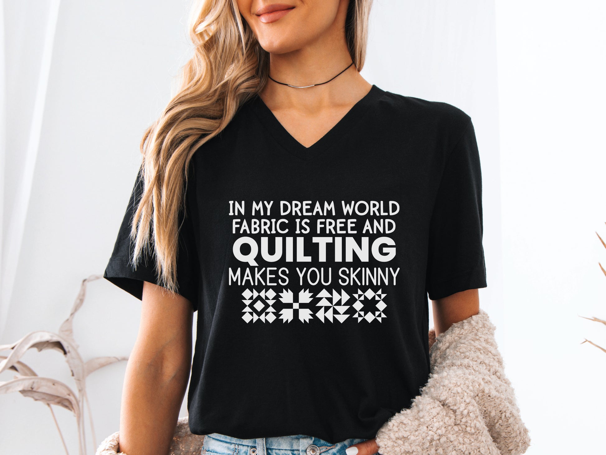 Quilting V-neck t-shirt with the humorous phrase “In My Dream World, Fabric Is Free and Quilting Makes You Skinny,” perfect for quilters and sewing retreats.